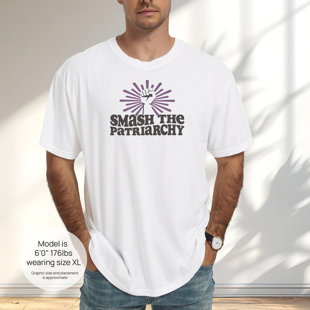 Male model wearing white t-shirt with a raised fist graphic and purple burst above the text “Smash the Patriarchy.” Includes size and fit information for the model who is 6 feet 0 inches, 176 pounds, and wearing a size XL shirt.
