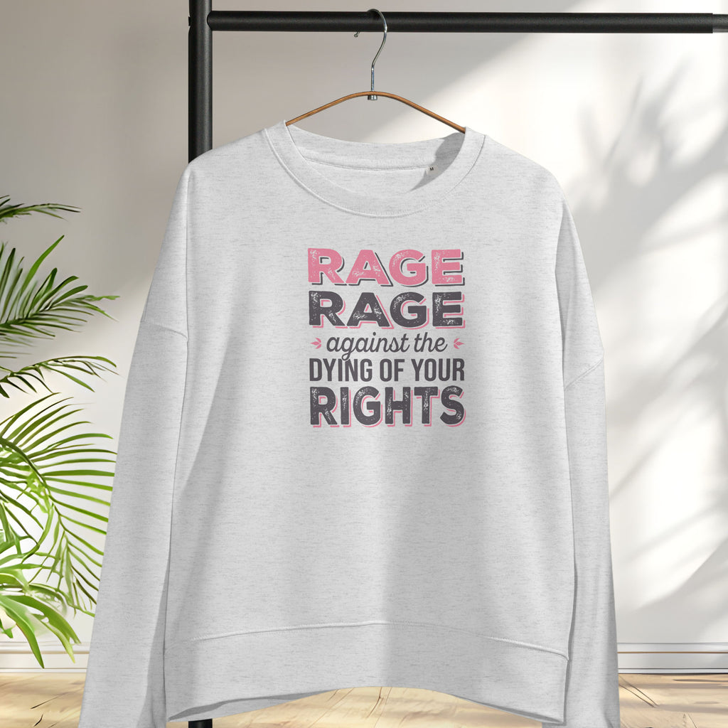 Grey women's protest sweatshirt with bold pink and grey text reading “rage rage against the dying of your rights” – feminist anti-trump activist shirt, hanging on a hanger.