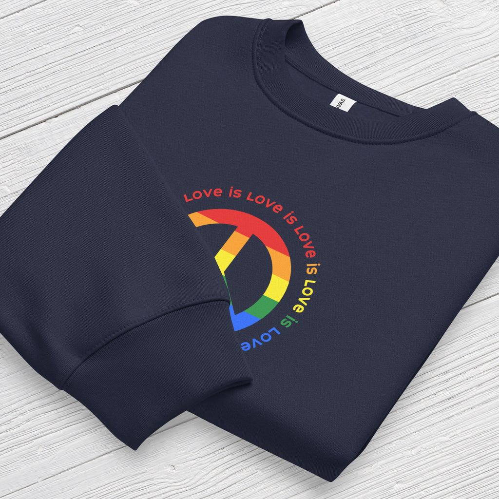 Folded navy sweatshirt with LGBTQ pride graphic — a peace sign in the LGBTQ flag colors, with the text "love is love" repeated in a circle around the peace sign, showing cuff detail.