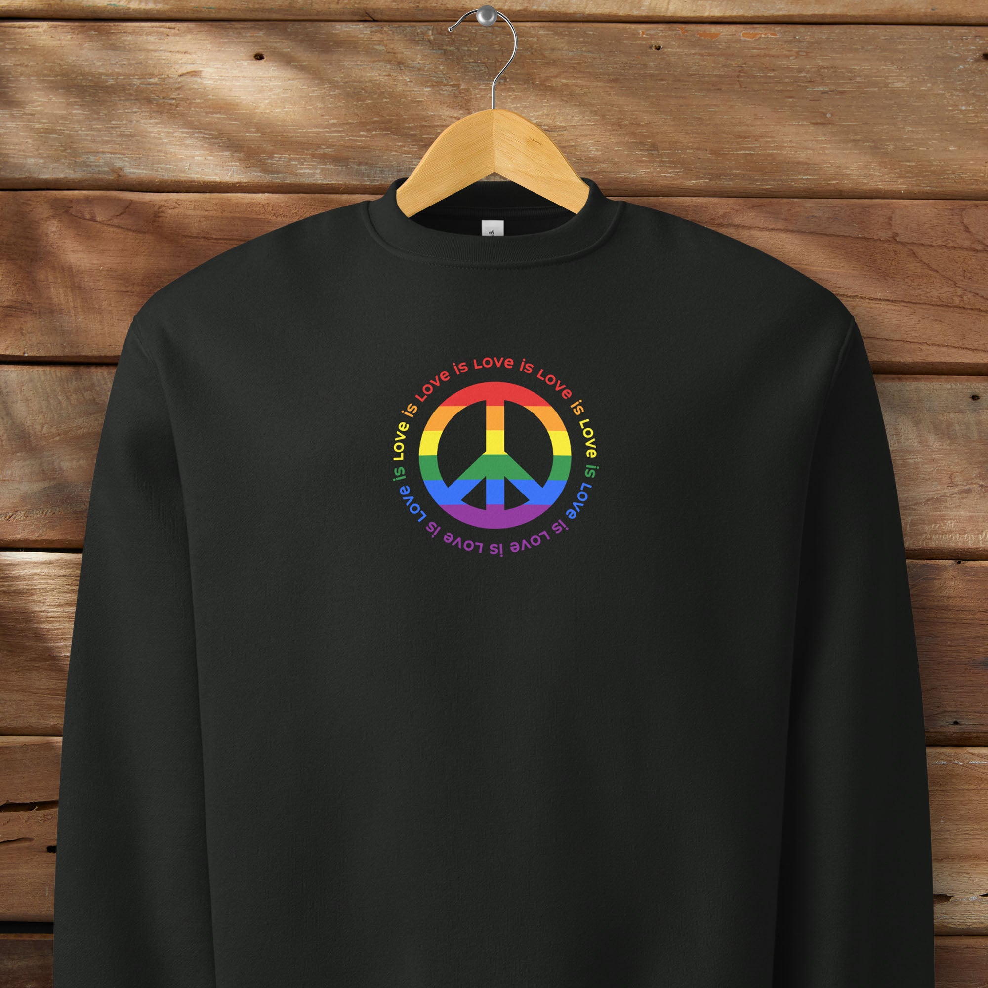 Black sweatshirt with LGBTQ pride graphic — a peace sign in the LGBTQ flag colors, with the text 