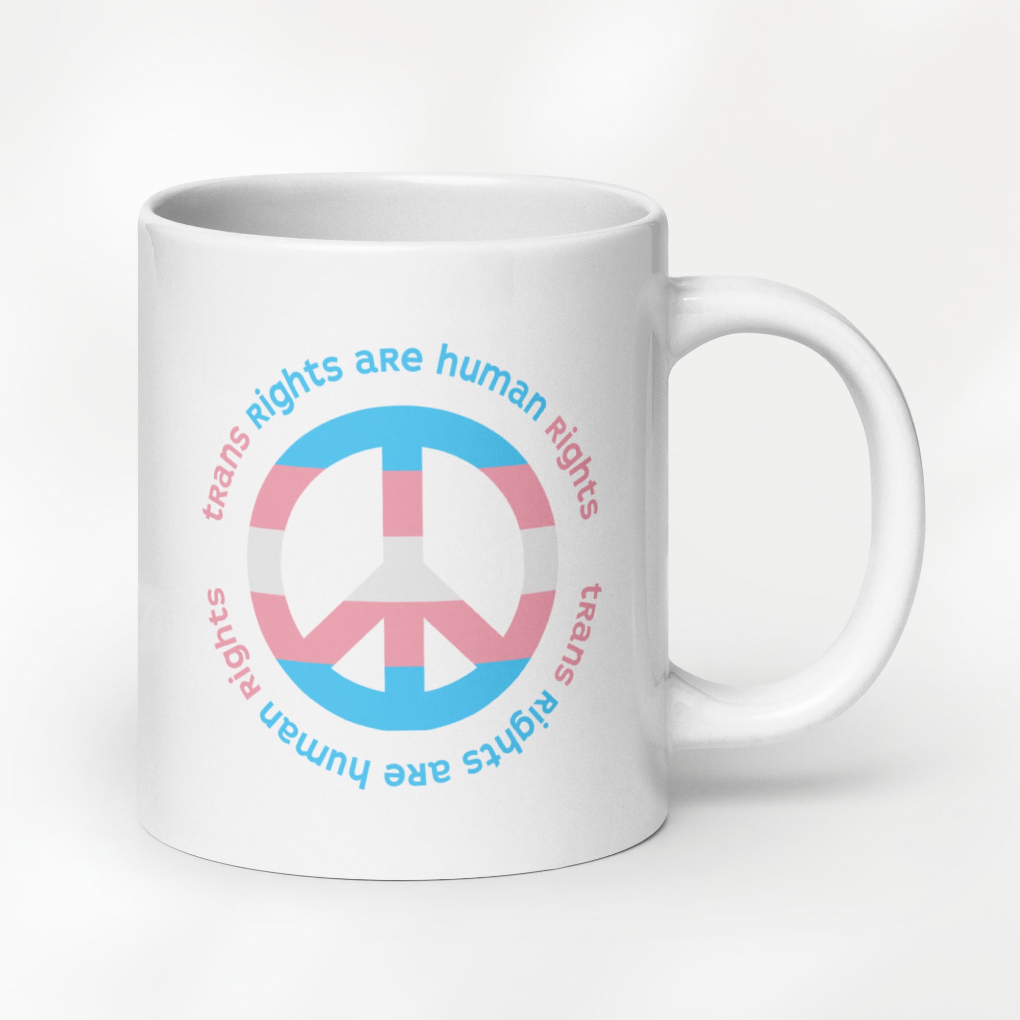 20 ounce ceramic mug with a peace sign in transgender flag colors and the text “Trans Rights Are Human Rights” in a circular design around the peace sign.