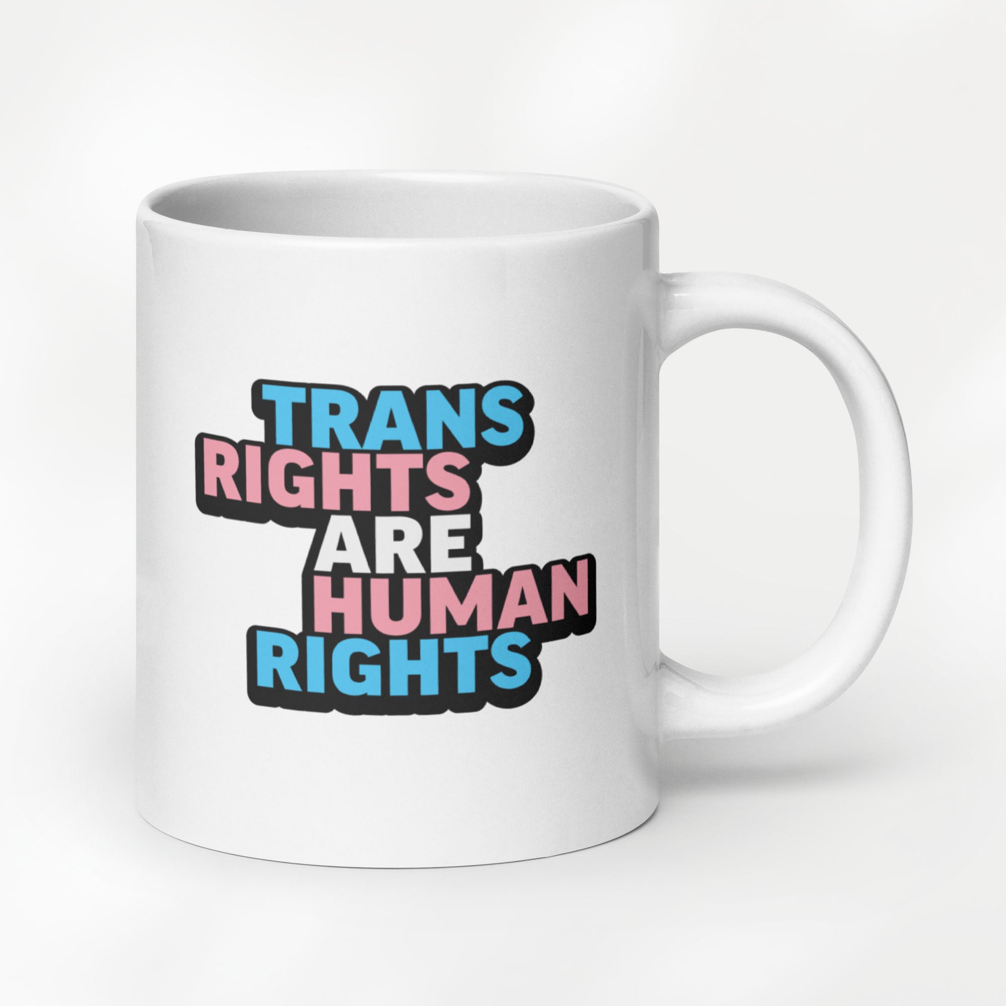 20 ounce white ceramic mug with bold text “Trans Rights Are Human Rights” in blue, pink, and black colors representing the transgender pride flag.