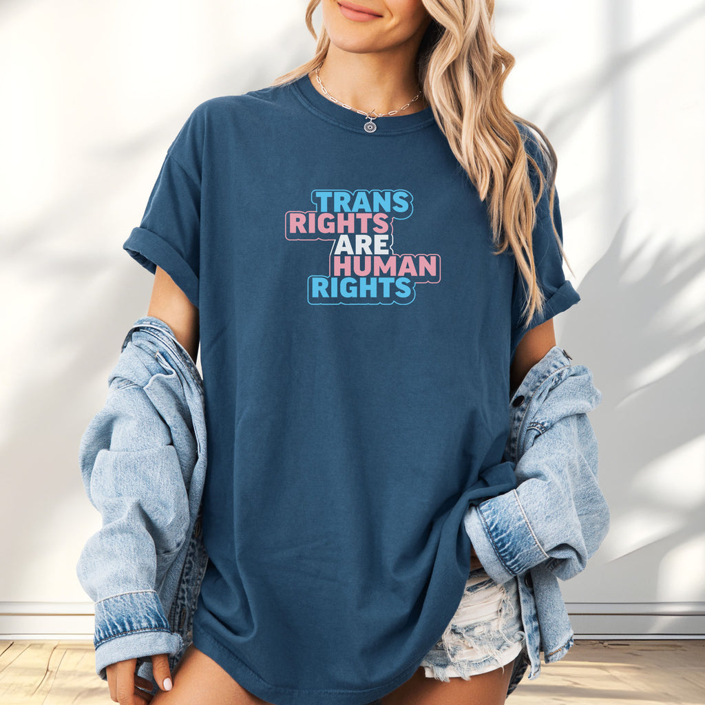 Female model wearing midnight t-shirt with graphic reading "trans rights are human rights" in the colors of the trans flag.