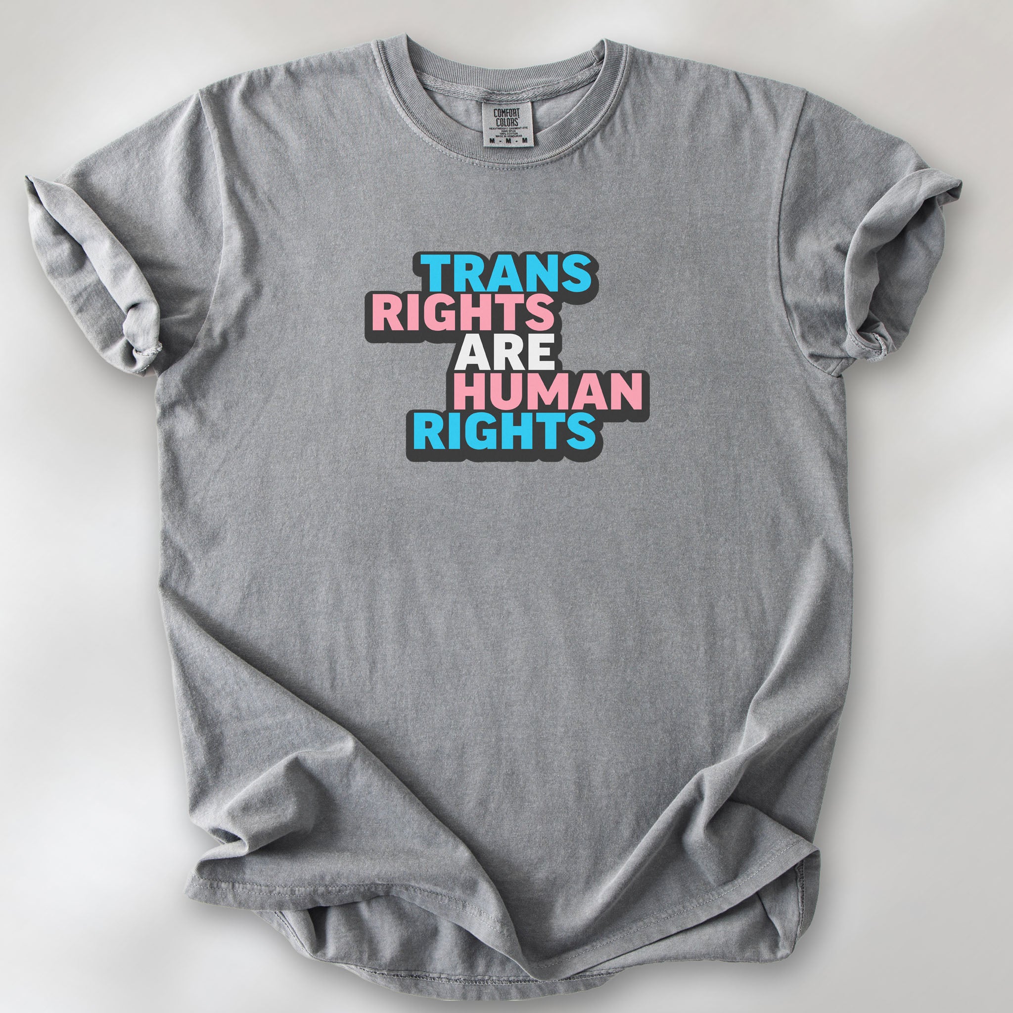 Grey t-shirt with graphic reading "trans rights are human rights" in the colors of the trans flag.