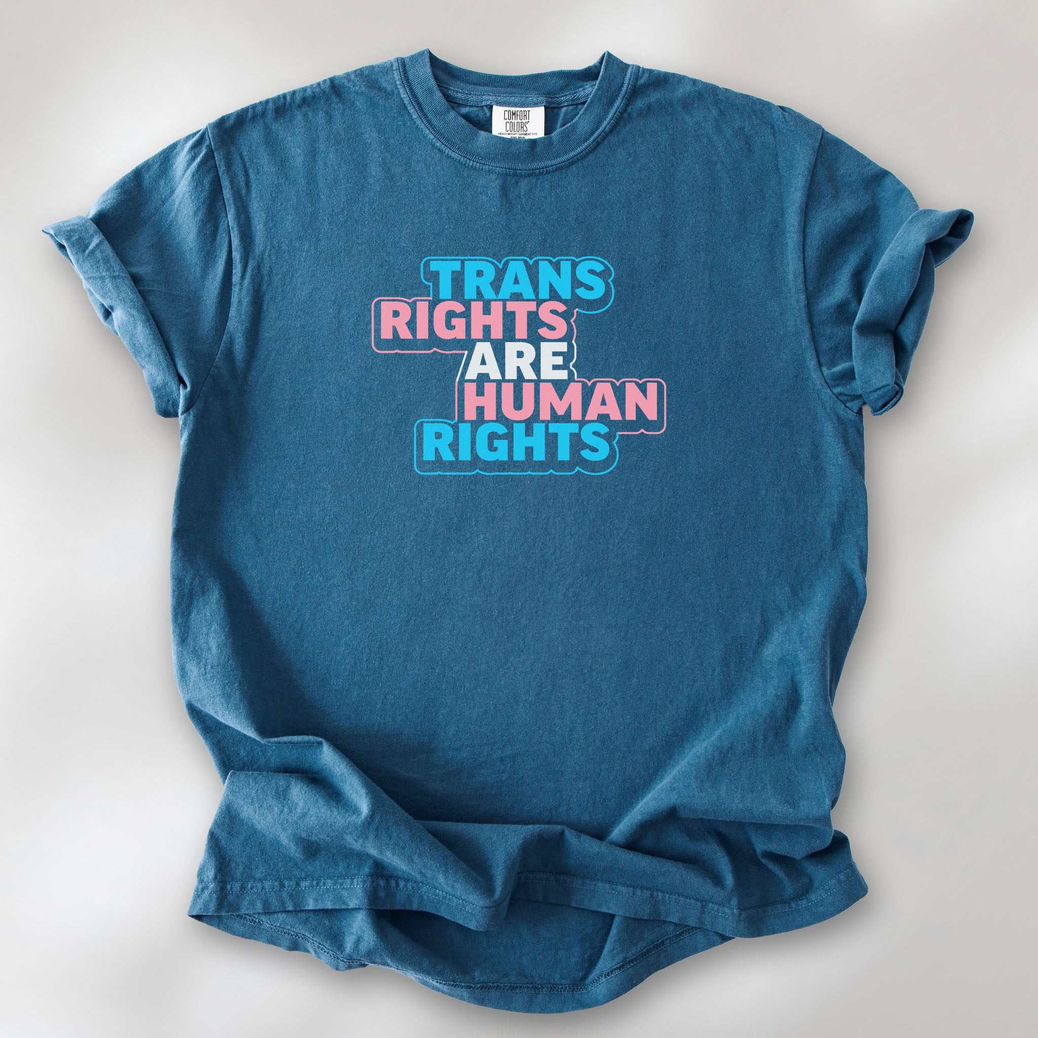 Midnight t-shirt with graphic reading "trans rights are human rights" in the colors of the trans flag.