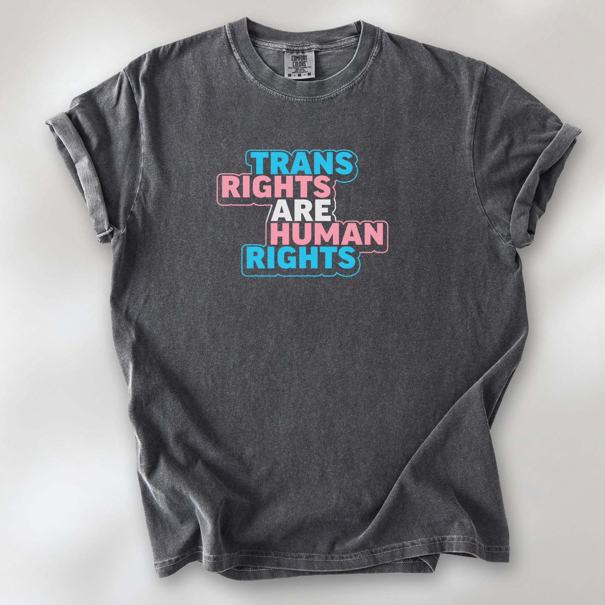 Pepper t-shirt with graphic reading "trans rights are human rights" in the colors of the trans flag.