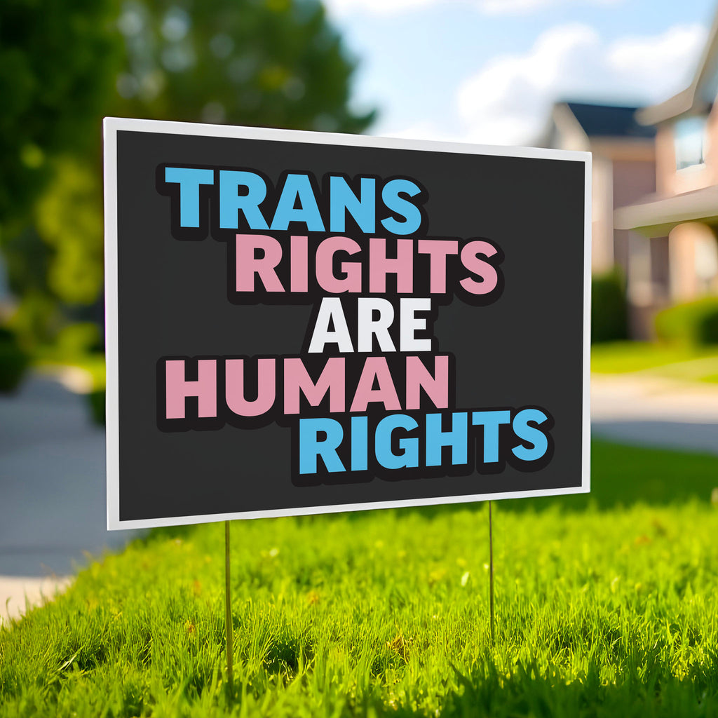 Yard sign that reads “Trans Rights Are Human Rights” in blue, pink, and white lettering, symbolizing support for transgender equality and resistance to discrimination under the Trump administration.