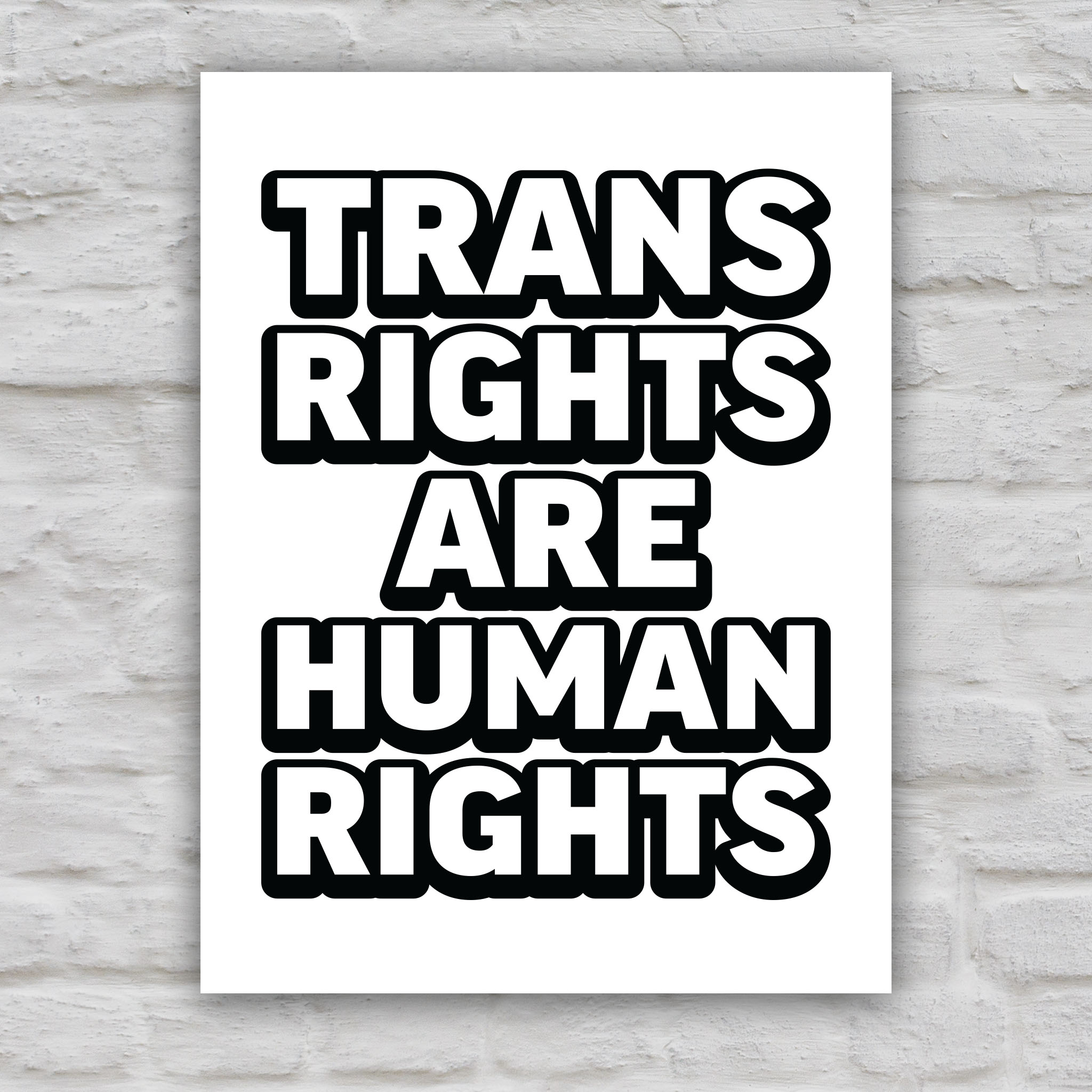 Black and white version of protest sign that reads “Trans Rights Are Human Rights” in bold lettering, symbolizing support for transgender equality and resistance to discrimination under the Trump administration.