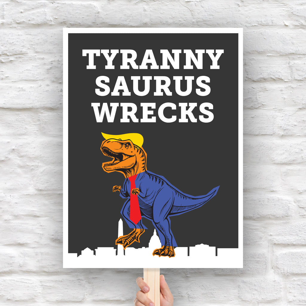 Funny anti-trump protest sign featuring a line drawing of a t-rex tyrannosaurus rex dinosaur with orange skin, wearing a blue suit, red tie, and yellow hair resembling Donald Trump, with the caption “TYRANNY SAURUS WRECKS” in bold white letters above. The dinosaur is stepping on a silhouette of the Washington D.C. skyline.