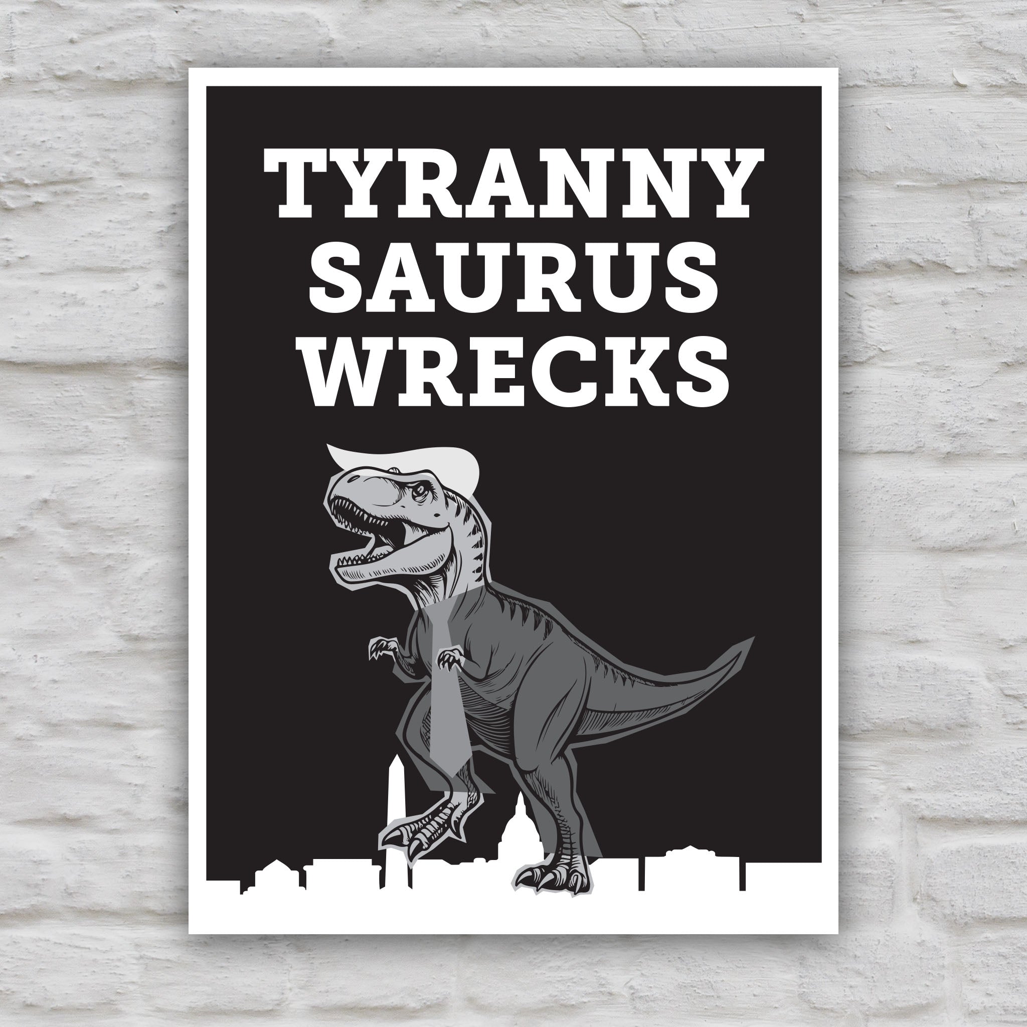 Black and white version of funny anti-trump protest sign featuring a line drawing of a t-rex tyrannosaurus rex dinosaur in greyscale resembling Donald Trump, with the caption “TYRANNY SAURUS WRECKS” in bold white letters above. The dinosaur is stepping on a silhouette of the Washington D.C. skyline.