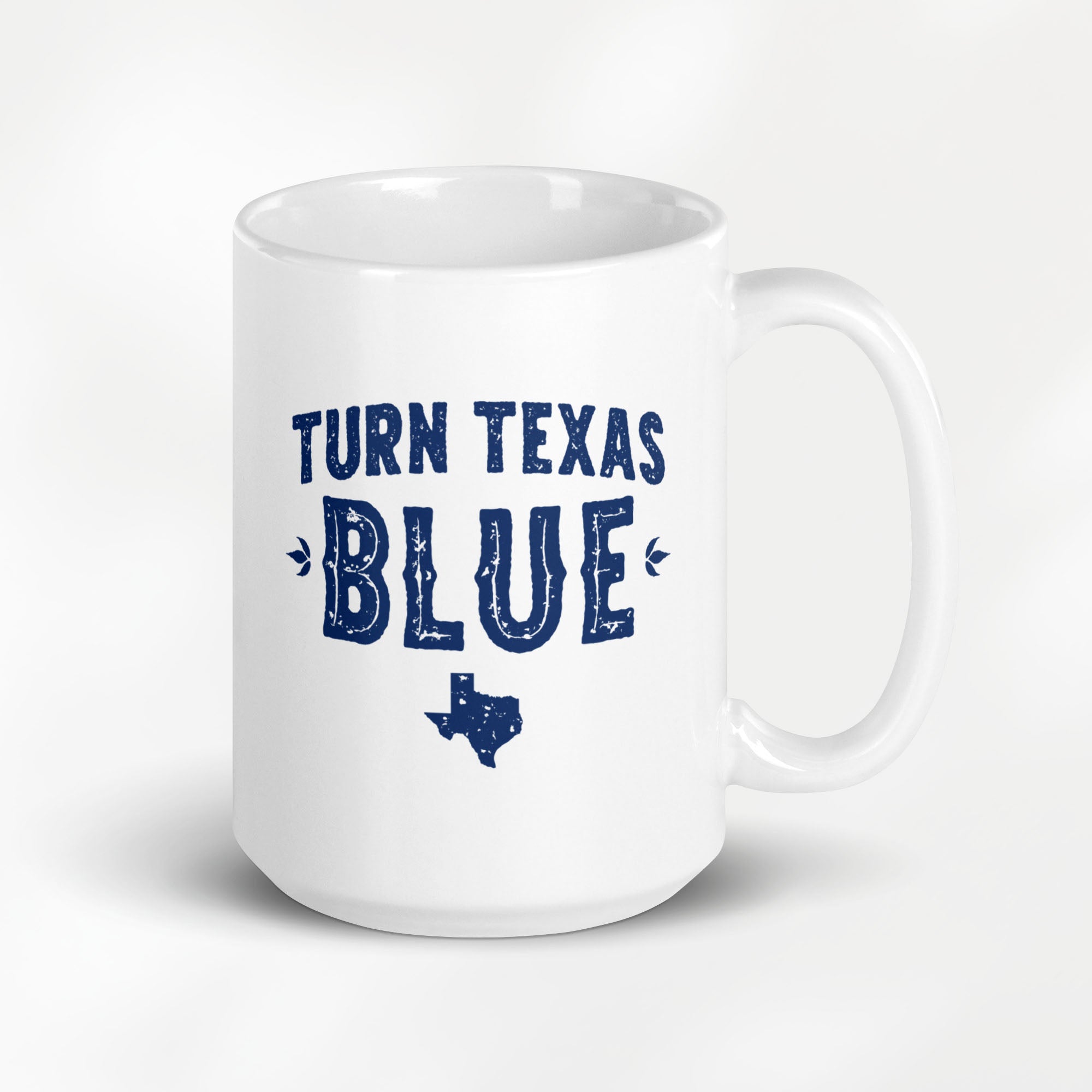 15 ounce white ceramic coffee mug featuring a distressed blue "Turn Texas Blue" design with a Texas state silhouette.