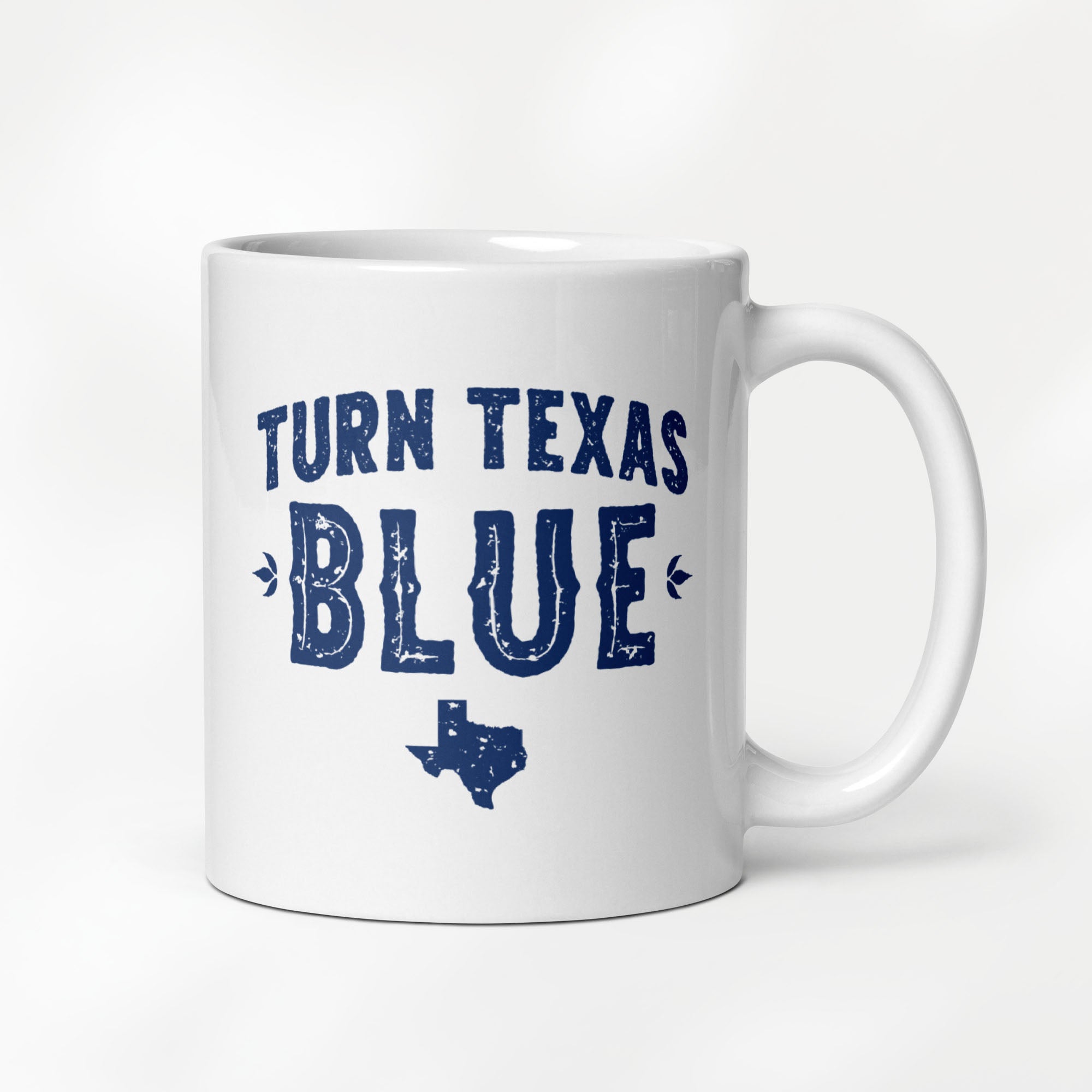 11 ounce white ceramic coffee mug featuring a distressed blue "Turn Texas Blue" design with a Texas state silhouette.