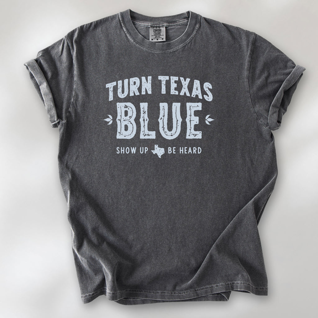 Pepper t-shirt featuring distressed "Turn Texas Blue" text with a small Texas icon and the phrase "Show Up Be Heard."