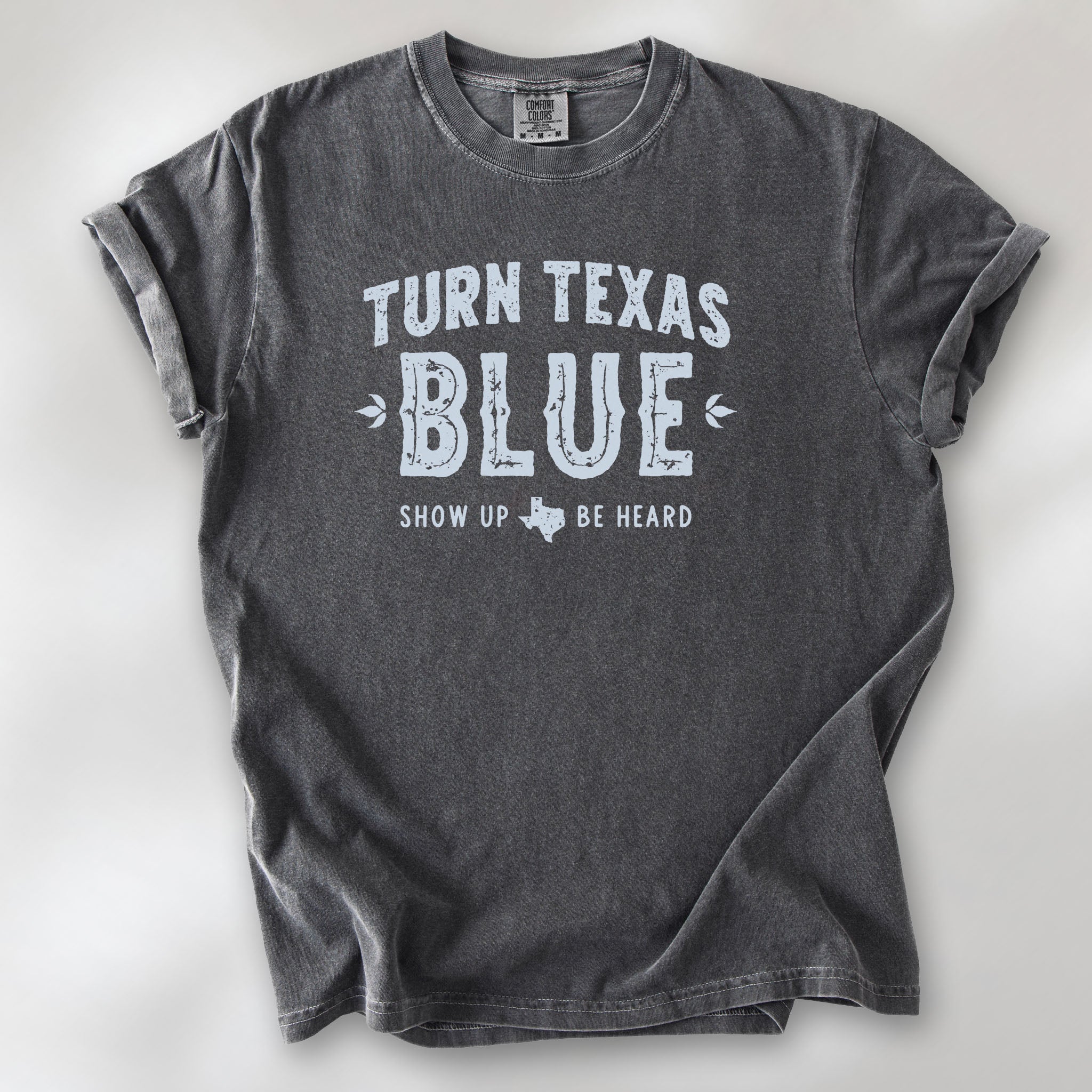 Pepper t-shirt featuring distressed "Turn Texas Blue" text with a small Texas icon and the phrase "Show Up Be Heard."