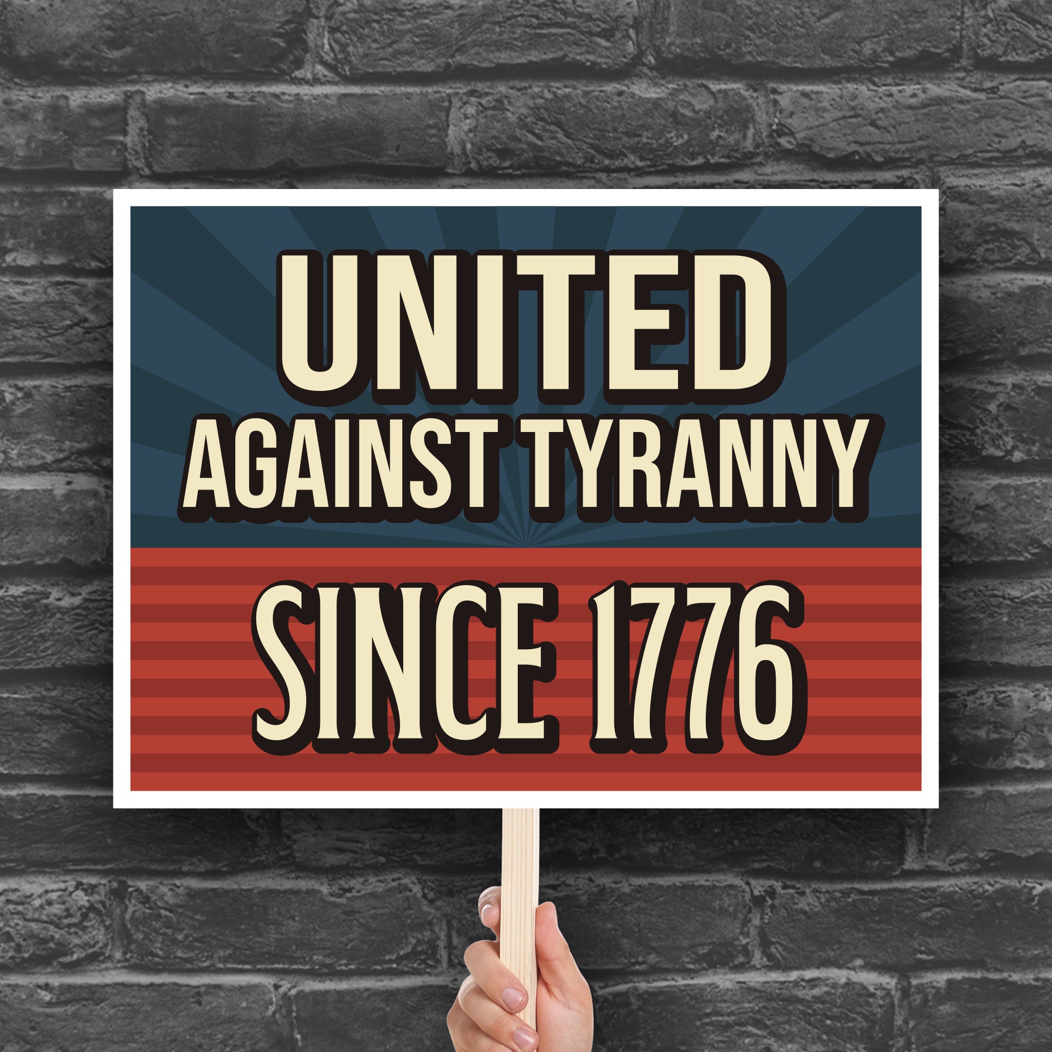Protest sign with blue and red background and gold text that reads "United against tyranny since 1776."