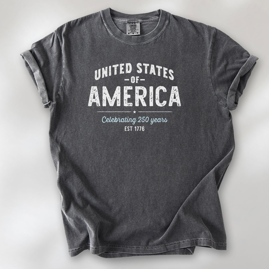 Pepper t-shirt with vintage style text reading “United States of America — Celebrating 250 Years — Est 1776”. 