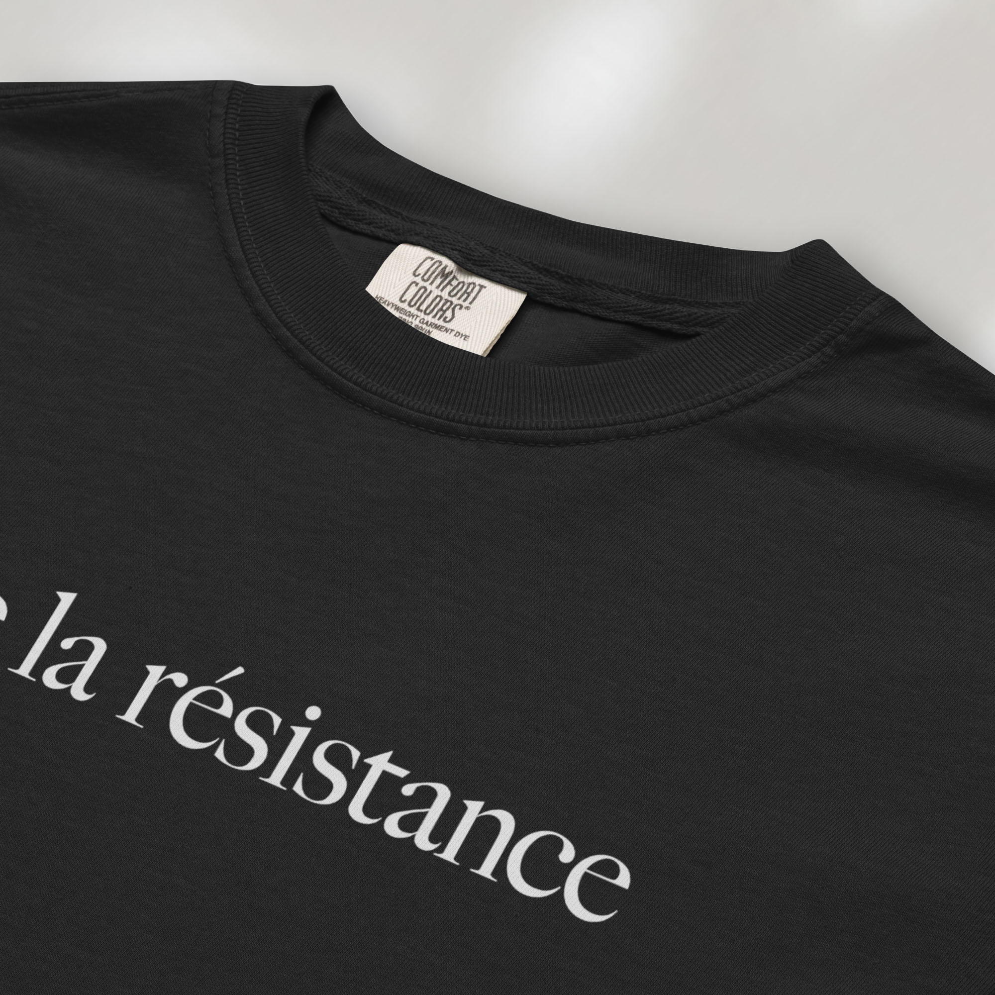 Closeup detail of black t-shirt with minimalist serif text reading “vive la résistance.”