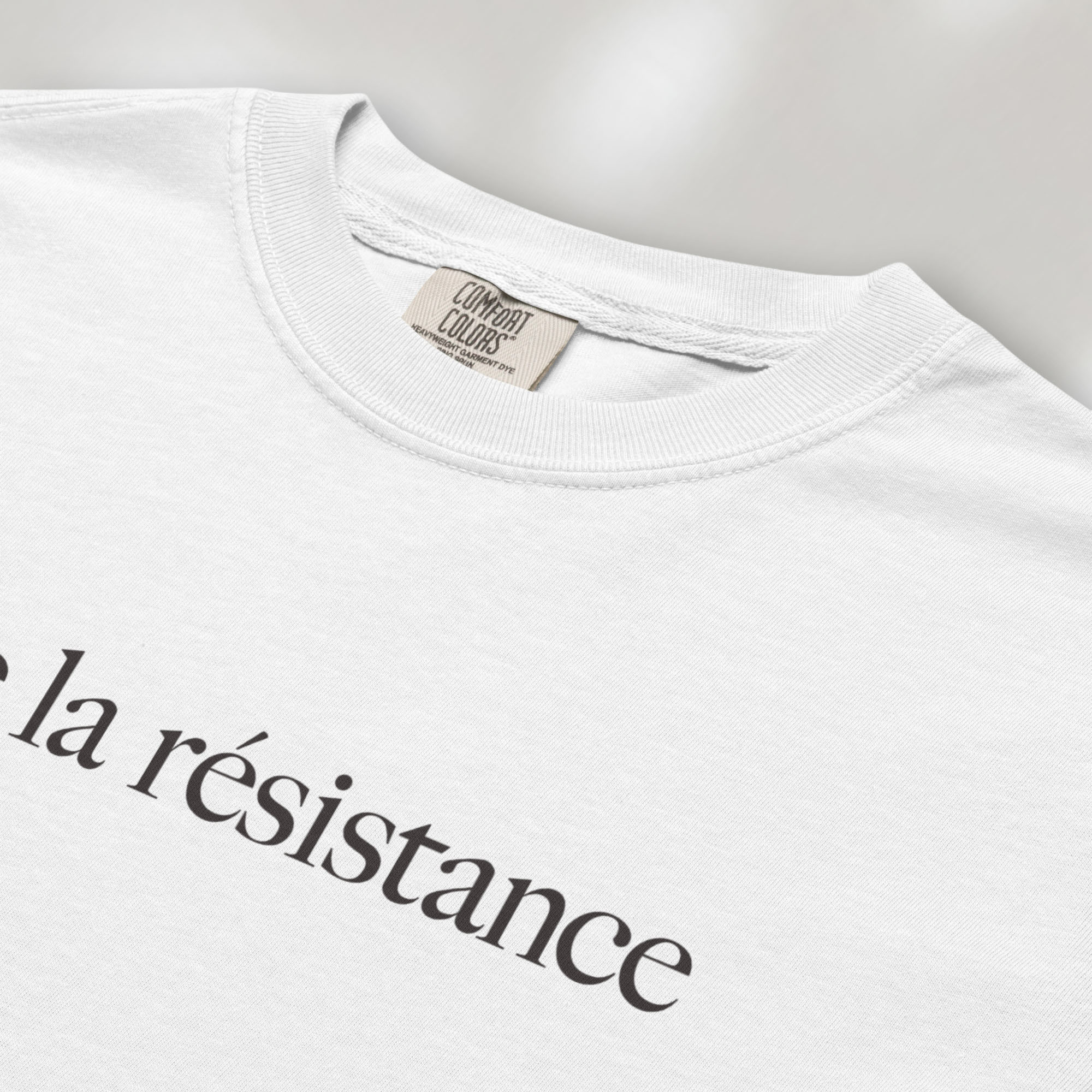 Closeup detail of white t-shirt with minimalist serif text reading “vive la résistance.”