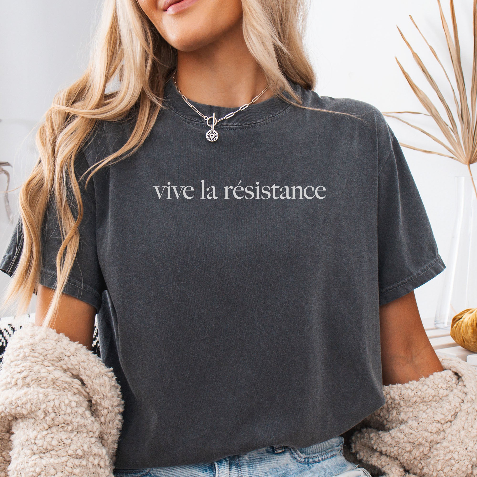 Female model wearing pepper t-shirt with minimalist serif text reading “vive la résistance.”