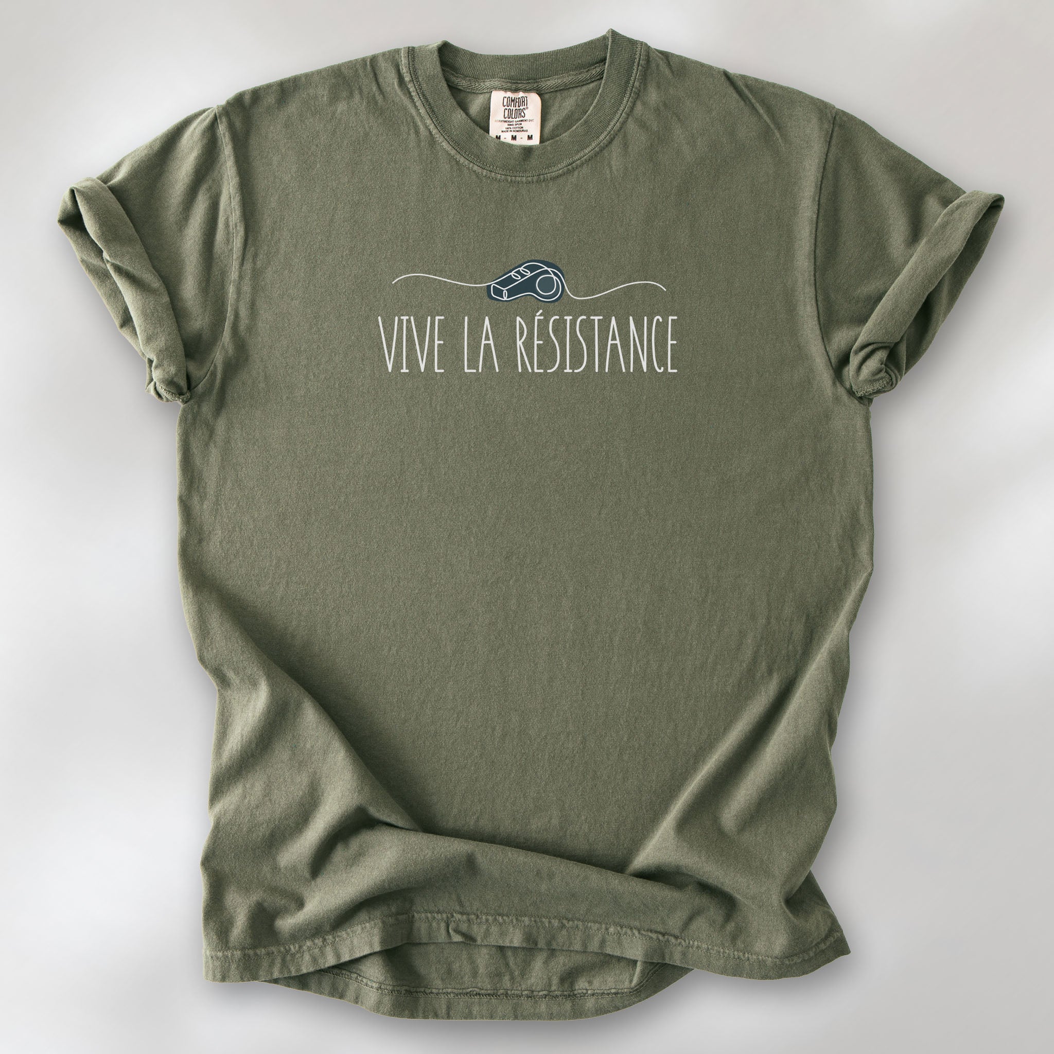 Sage unisex t-shirt reading “Vive La Resistance” with a whistle illustration referencing community alert systems used to warn neighbors of ICE presence.
