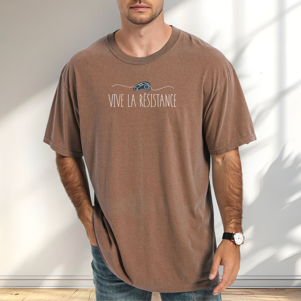 Male model wearing espresso unisex t-shirt reading “Vive La Resistance” with a whistle illustration referencing community alert systems used to warn neighbors of ICE presence.