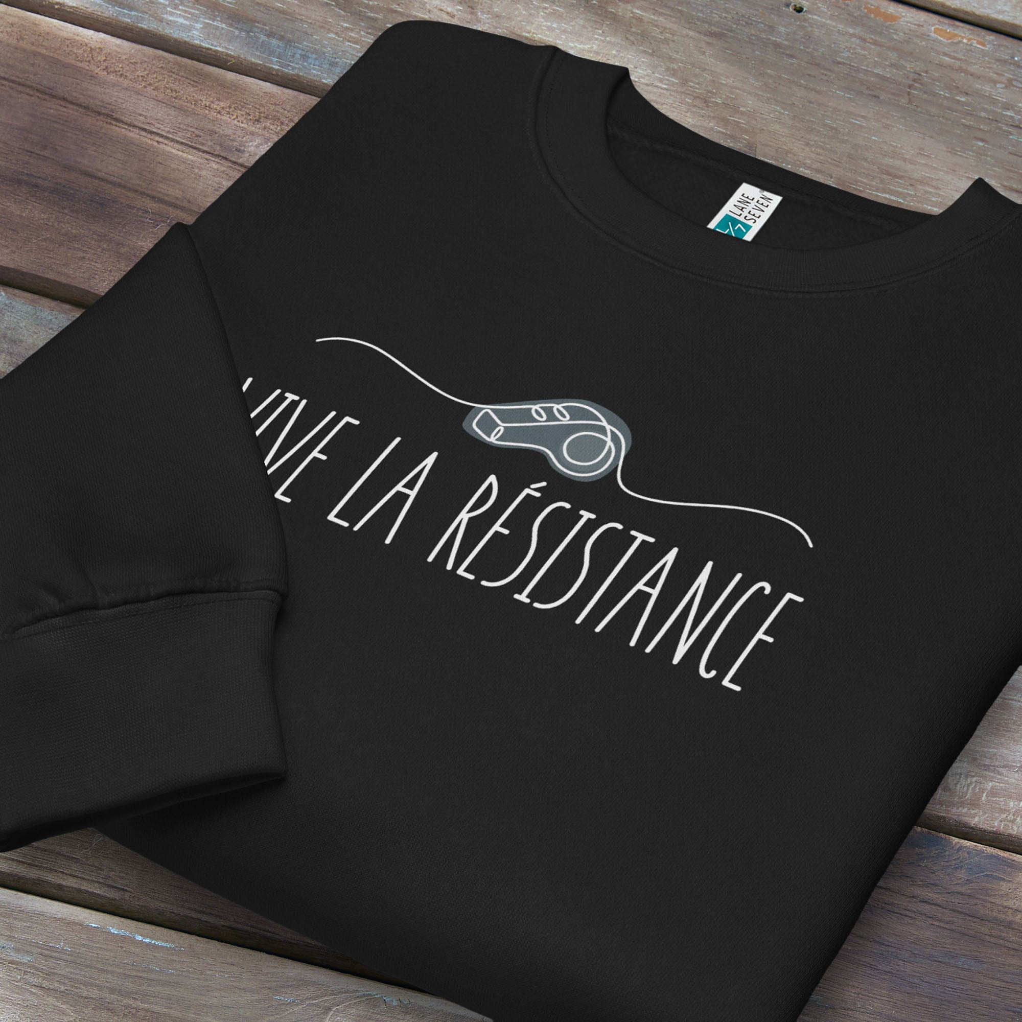Folded black sweatshirt reading “Viva La Resistance” with a whistle illustration referencing community alert systems used to warn neighbors of ICE presence.