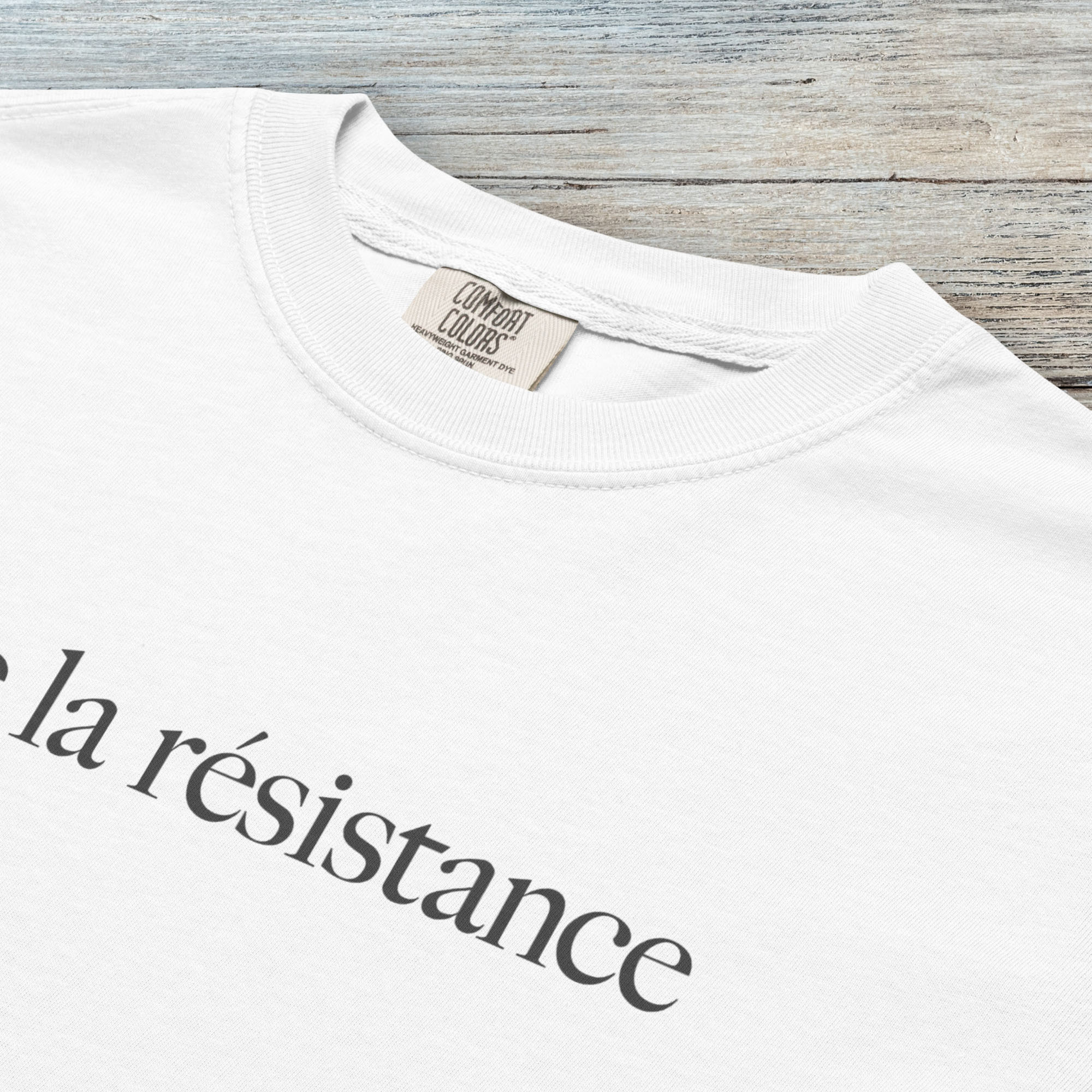 Closeup detail of white t-shirt with minimalist serif text reading “vive la résistance."