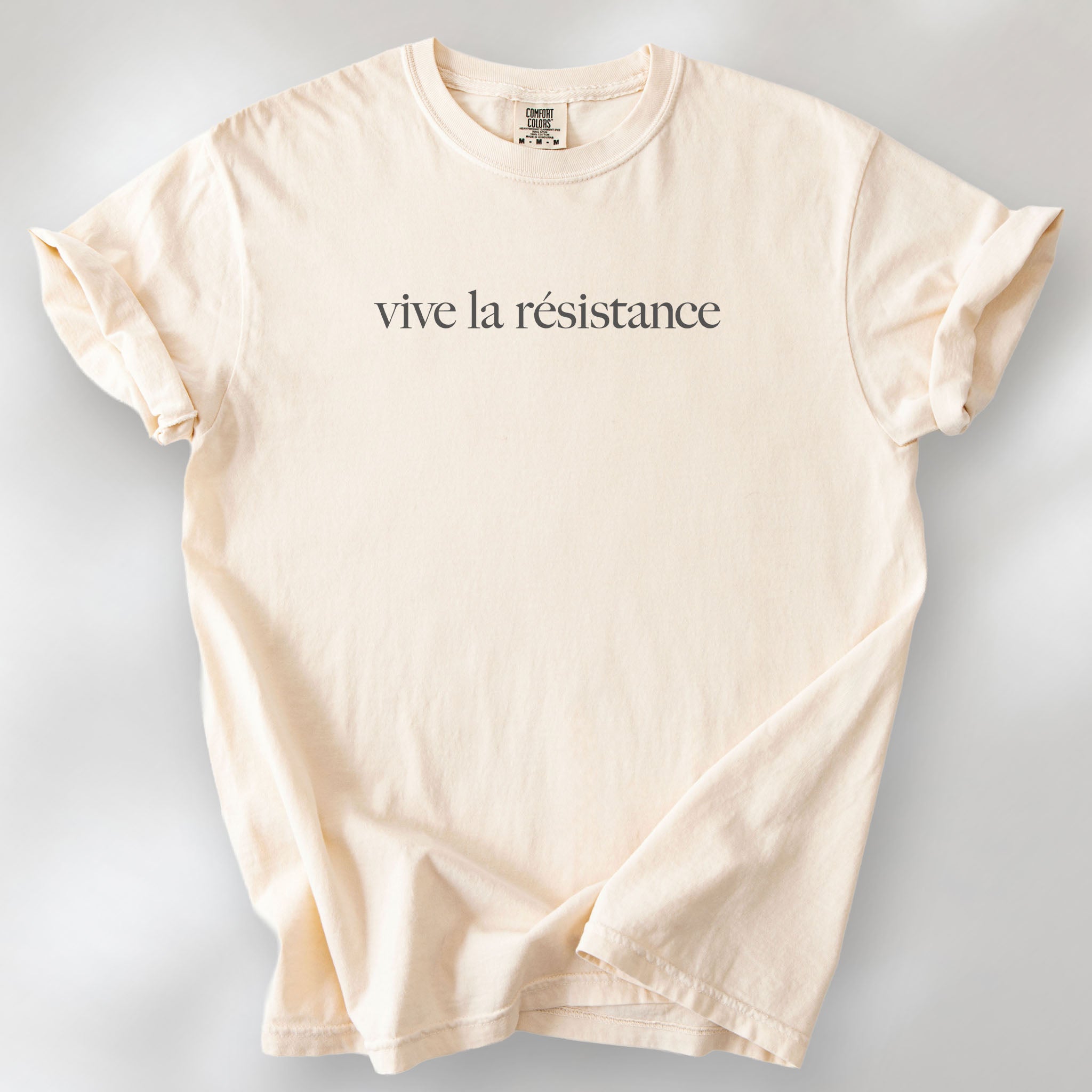 Ivory t-shirt with minimalist serif text reading “vive la résistance.”