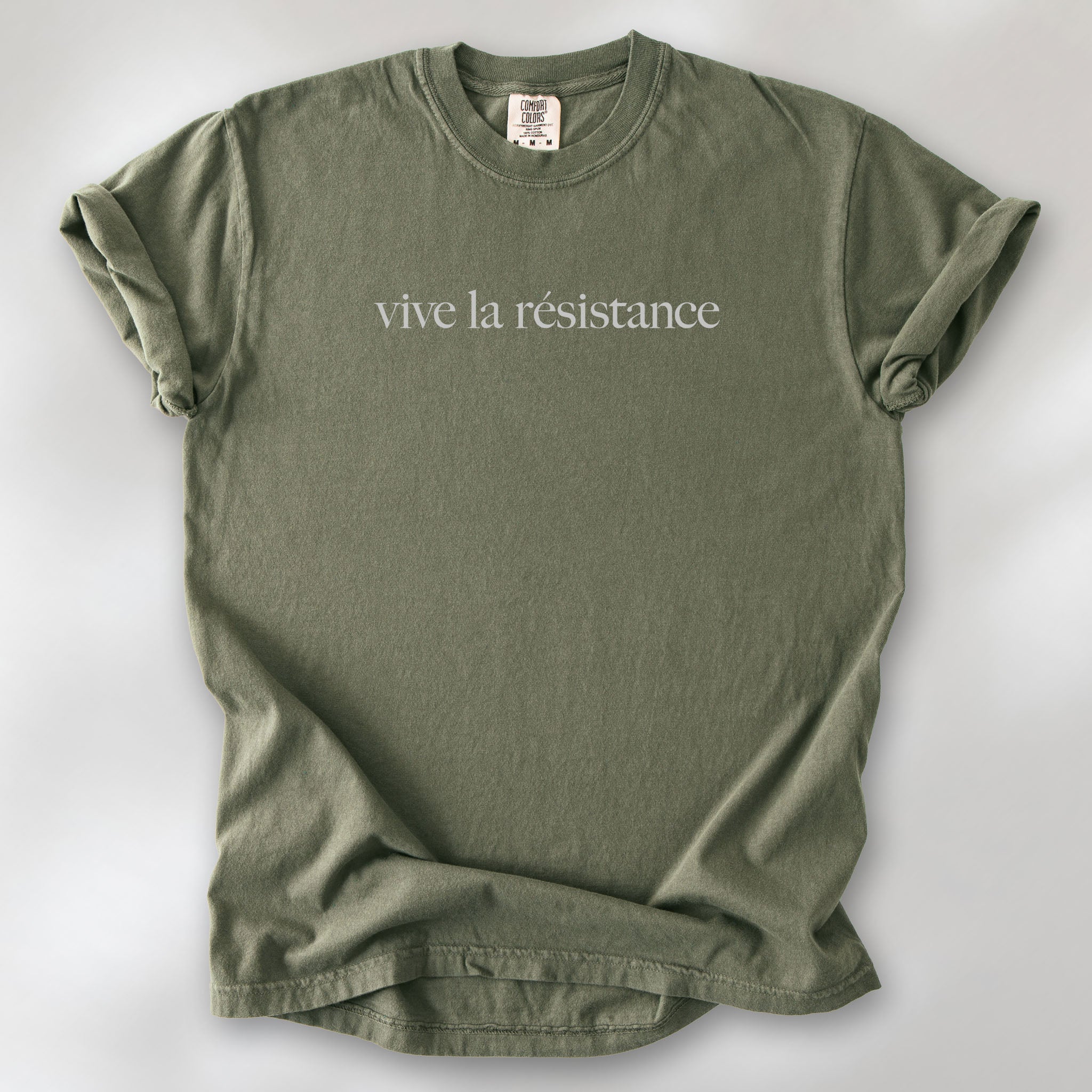 Sage t-shirt with minimalist serif text reading “vive la résistance.”