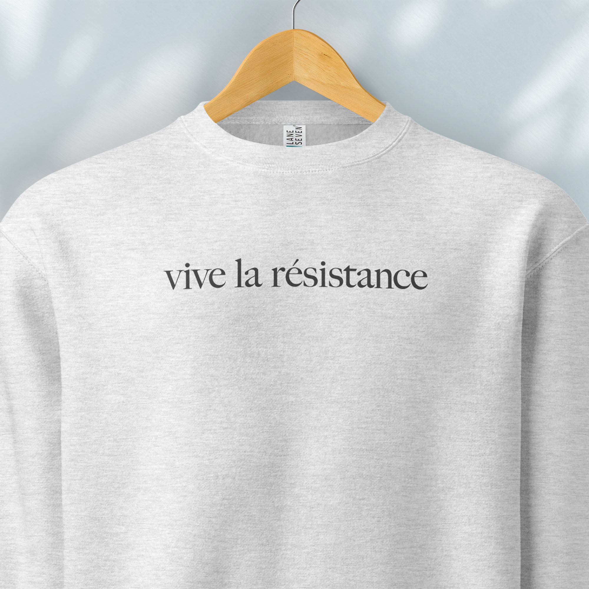 Hanging grey sweatshirt with minimalist serif text reading “vive la résistance.”