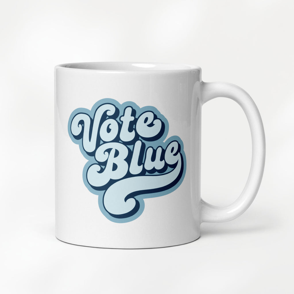 11 ounce white ceramic coffee mug featuring a retro blue “Vote Blue” script design.