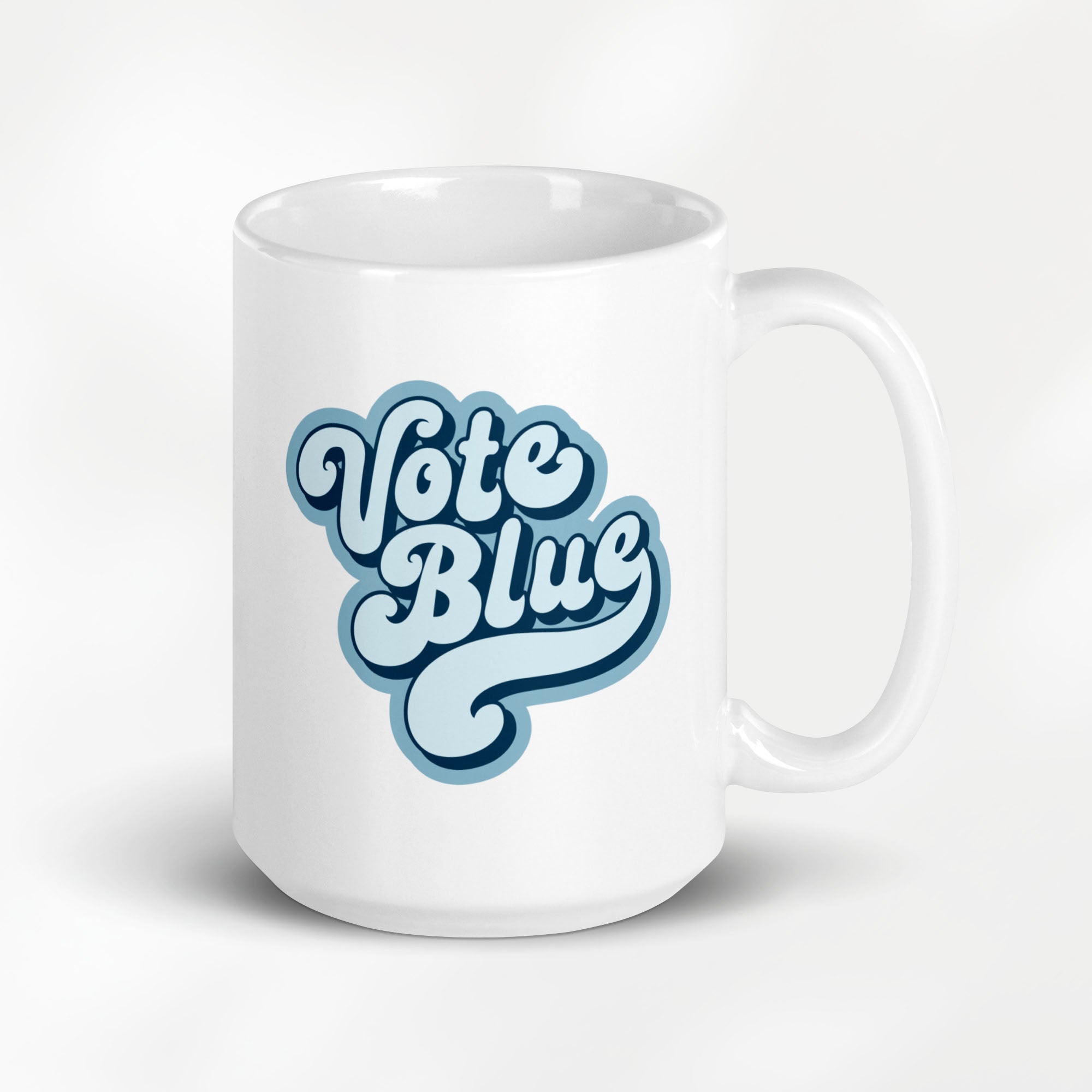 15 ounce white ceramic coffee mug featuring a retro blue “Vote Blue” script design.