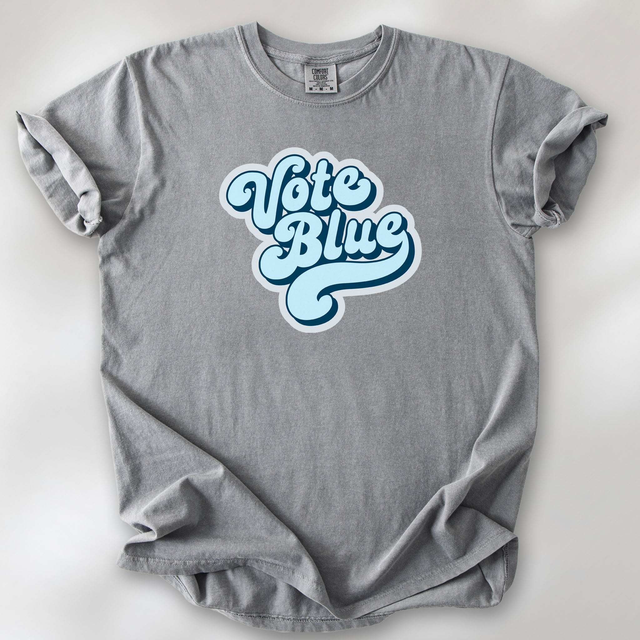 Grey t-shirt featuring a retro blue "Vote Blue" script graphic.