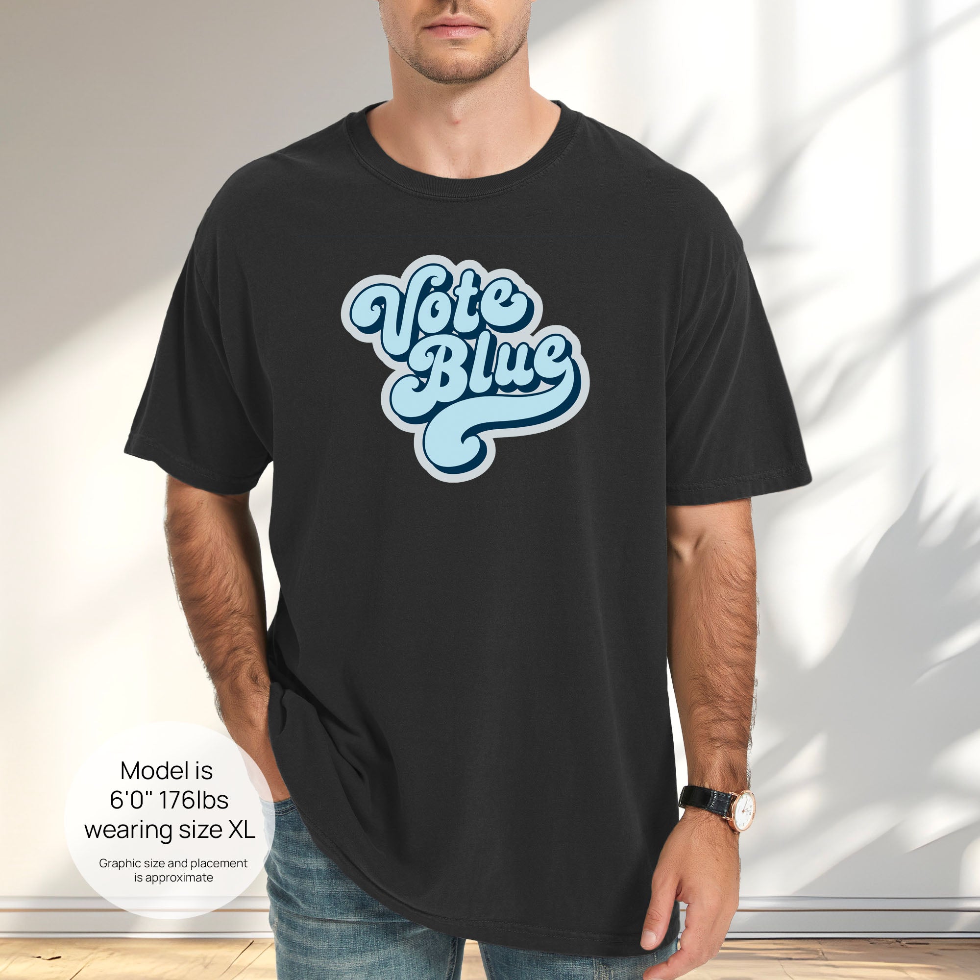 Male model wearing black t-shirt featuring a retro blue "Vote Blue" script graphic. Includes size and fit information for the model who is 6 feet 0 inches, 176 pounds, and wearing a size XL shirt.
