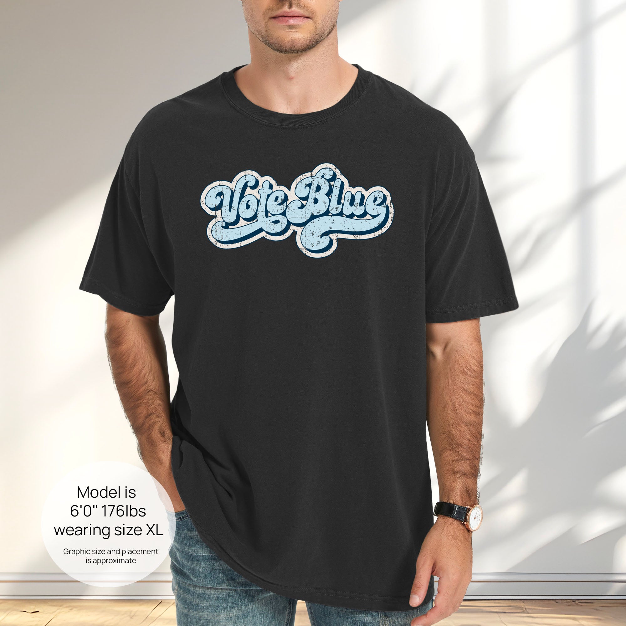Male model wearing black t-shirt featuring distressed retro script text reading "Vote Blue" in light blue vintage lettering. Includes size and fit information for the model who is 6 feet 0 inches, 176 pounds, and wearing a size XL shirt.
