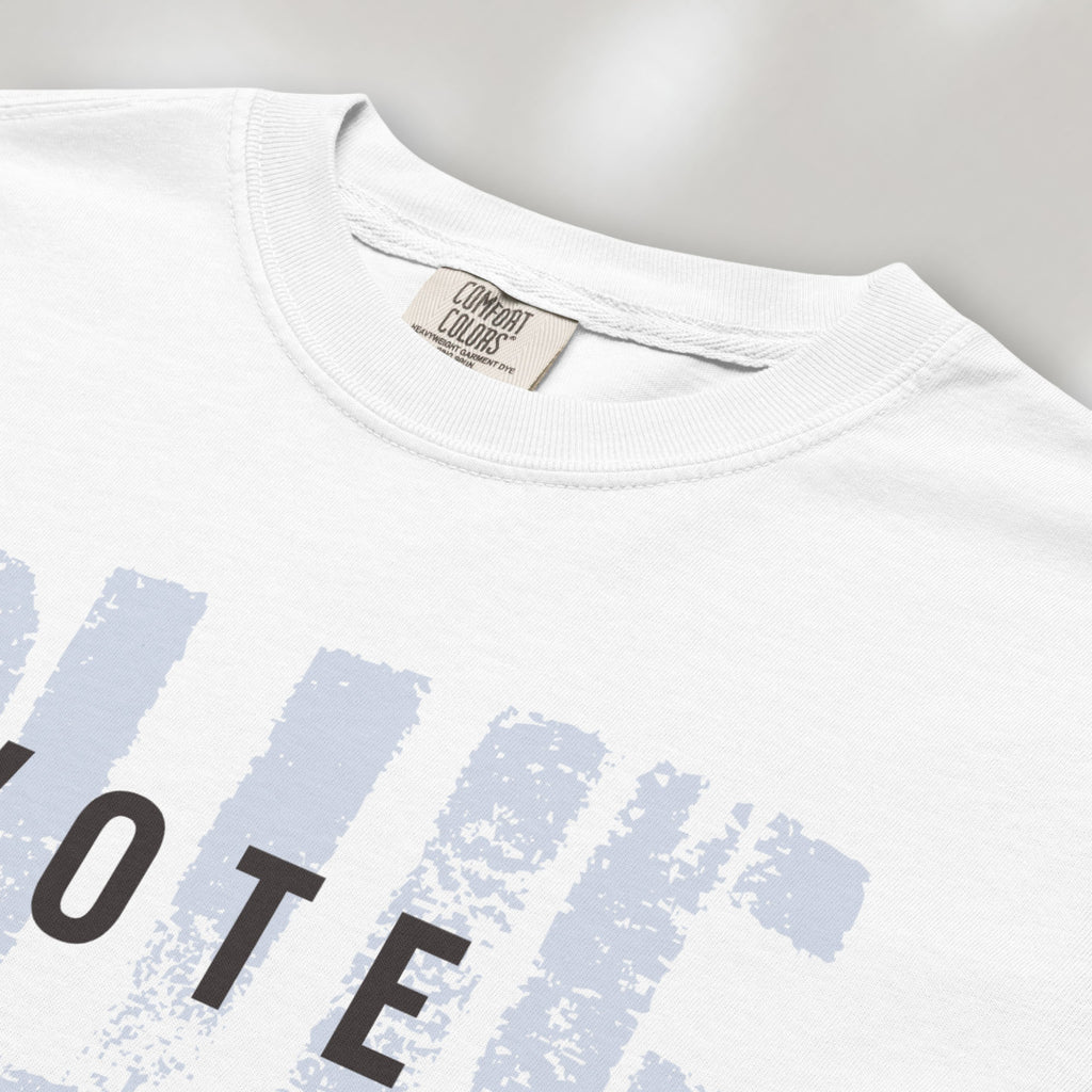 Closeup detail of white t-shirt with the word "vote" atop the word "blue" in a grunge background texture.