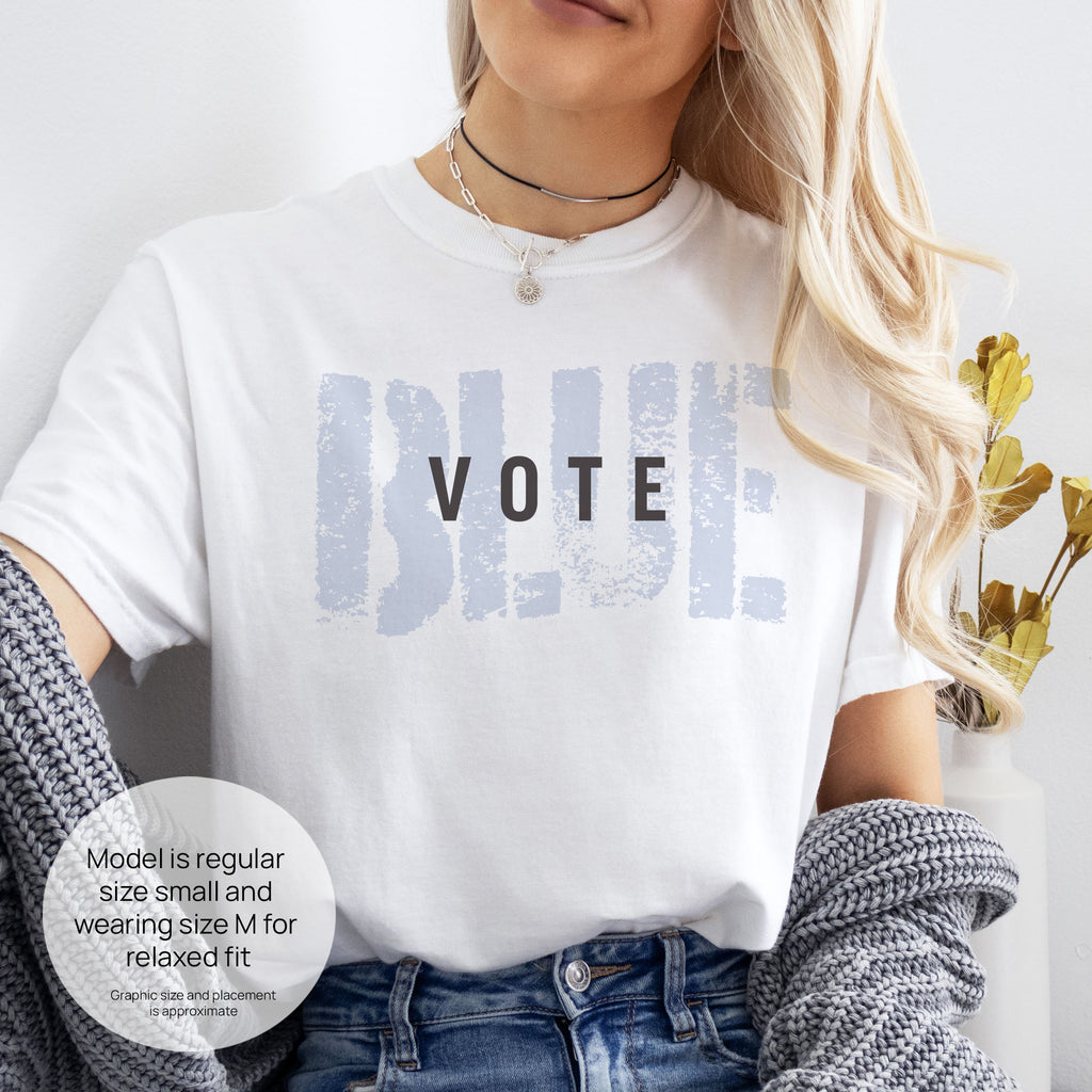 Female model wearing white t-shirt with the word "vote" atop the word "blue" in a grunge background texture.