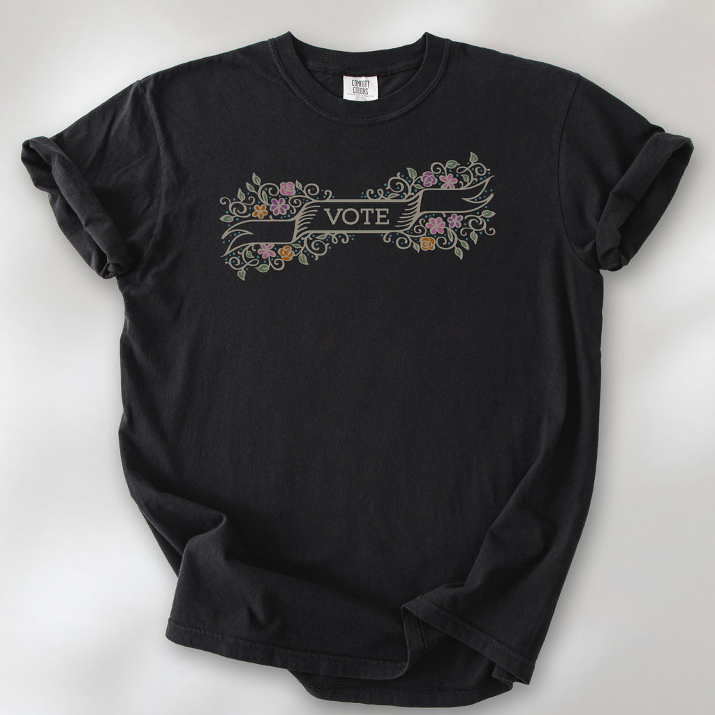 Black t-shirt with vintage style floral illustration and a banner reading “vote” in the center.