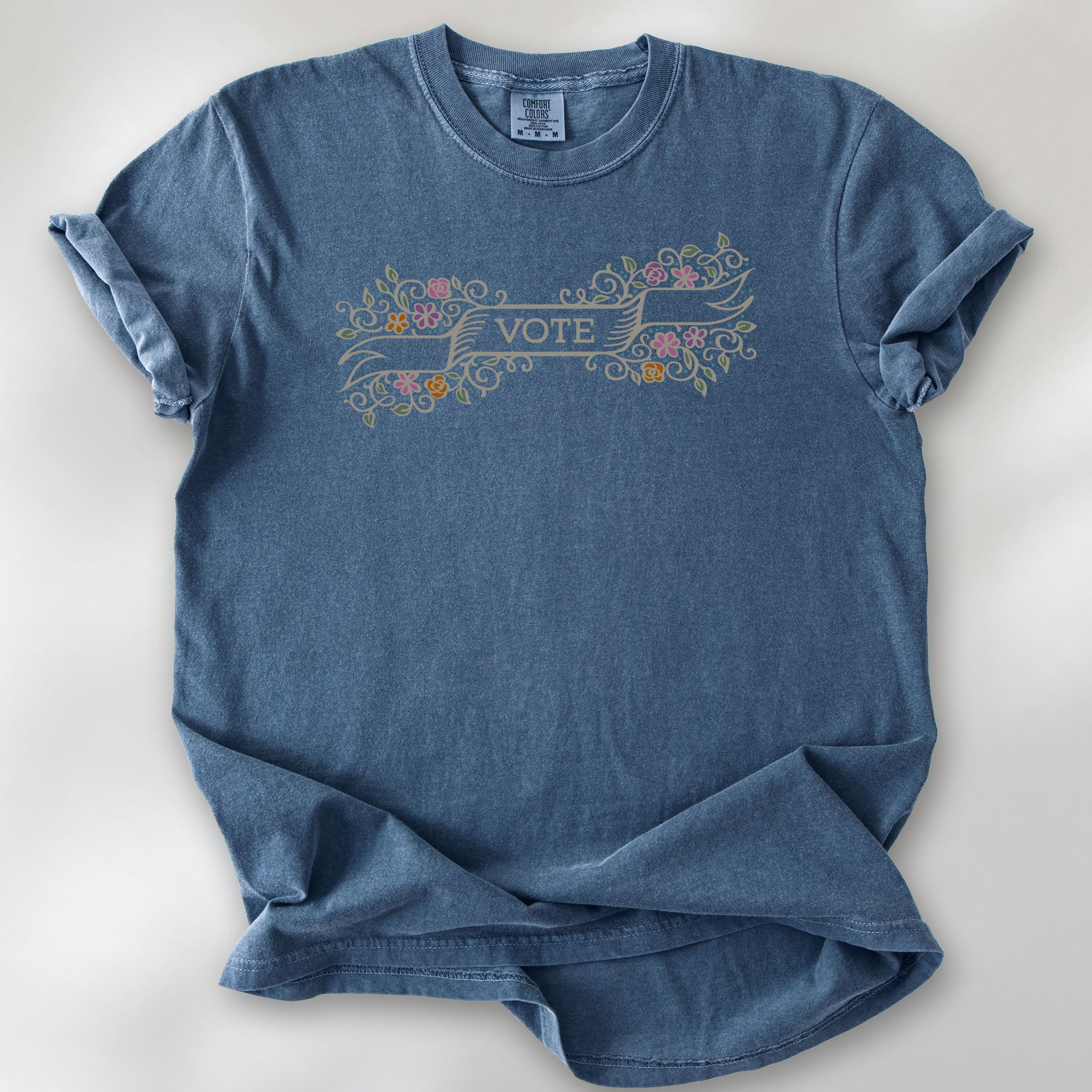 Denim t-shirt with vintage style floral illustration and a banner reading “vote” in the center.