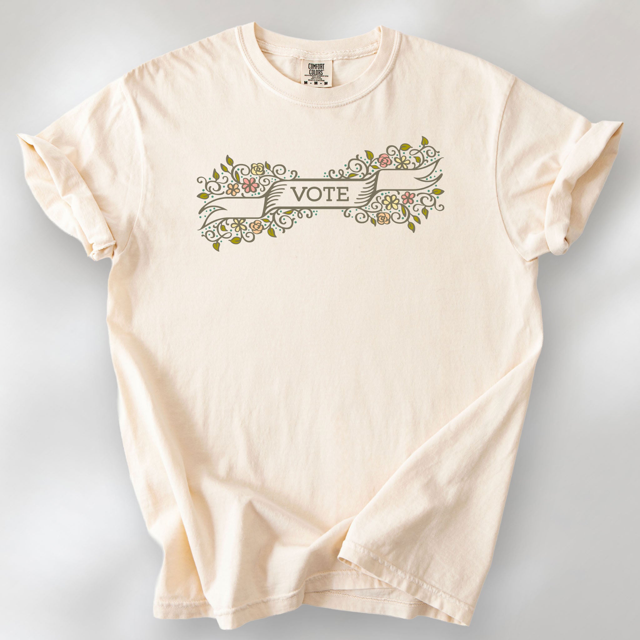 Ivory t-shirt with vintage style floral illustration and a banner reading “vote” in the center.