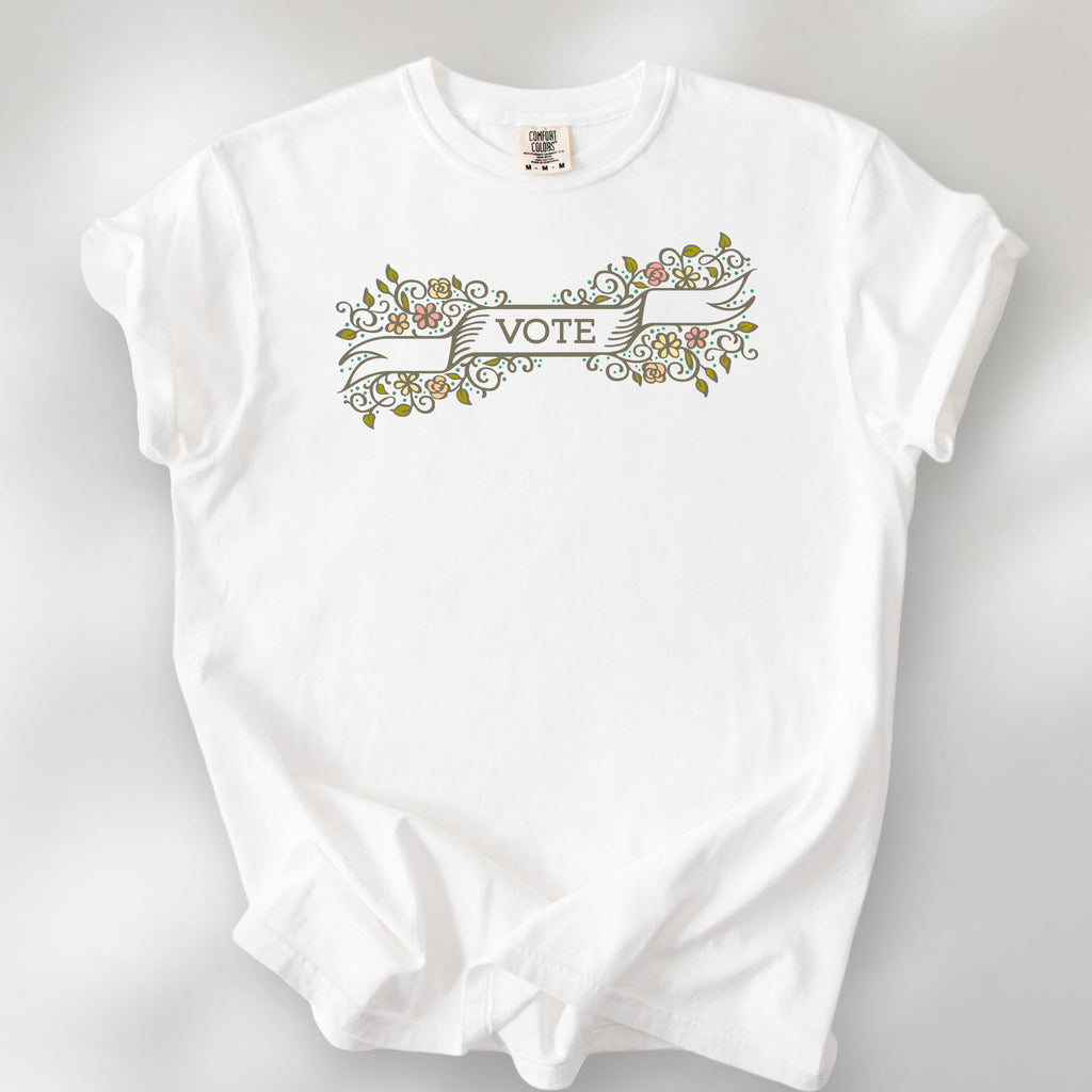 White t-shirt with vintage style floral illustration and a banner reading “vote” in the center.