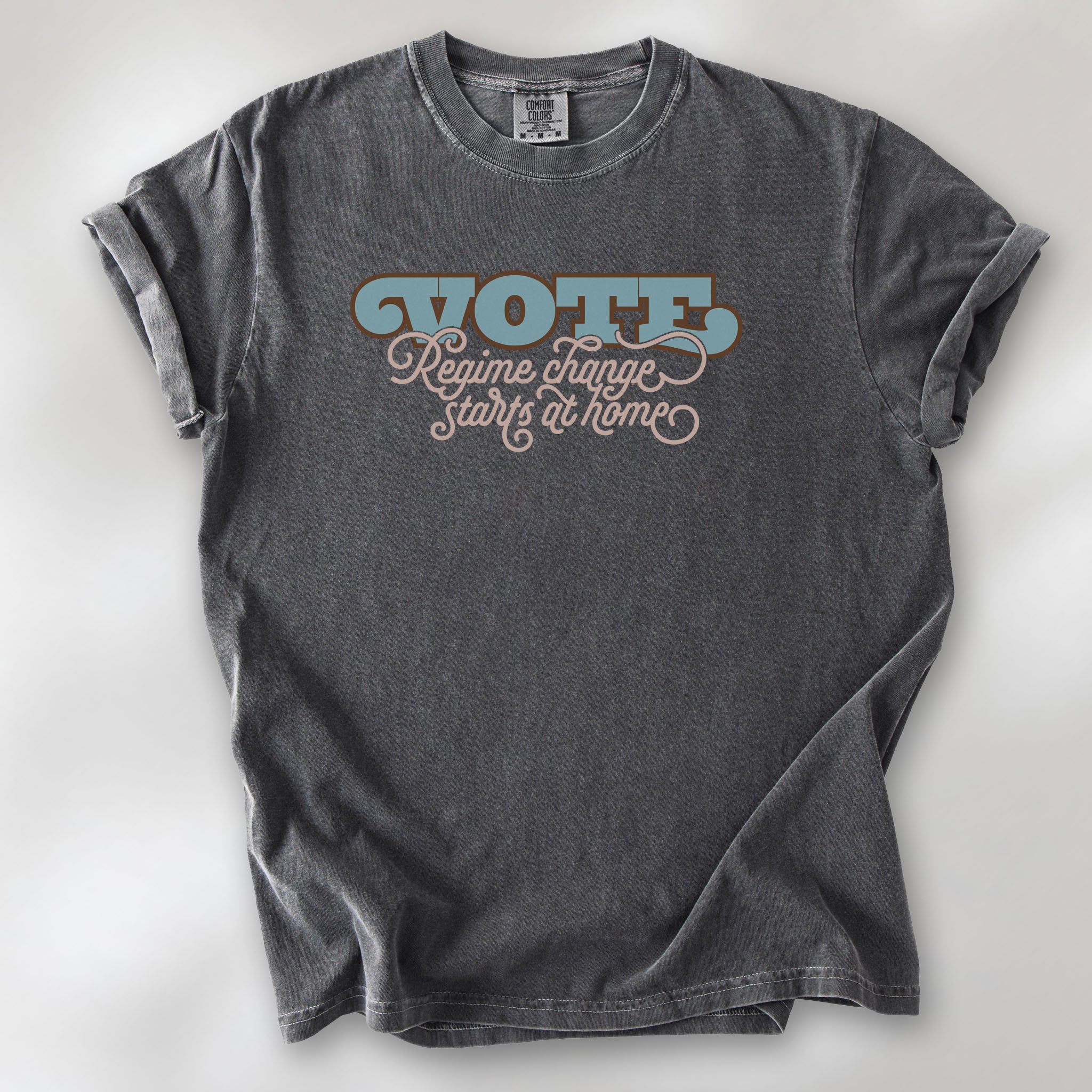 Pepper t-shirt with retro text reading “Vote: Regime Change Starts at Home,” promoting voting and political accountability.