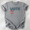 Grey t-shirt featuring a distressed retro "VOTE" graphic with blue stars and a vintage red and blue hand making a peace sign.