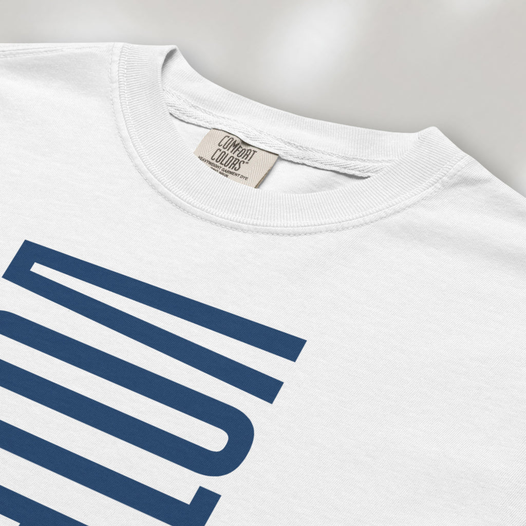 Closeup detail of white t-shirt featuring the words "VOTE BLUE" stacked vertically in bold minimalist blue typography.