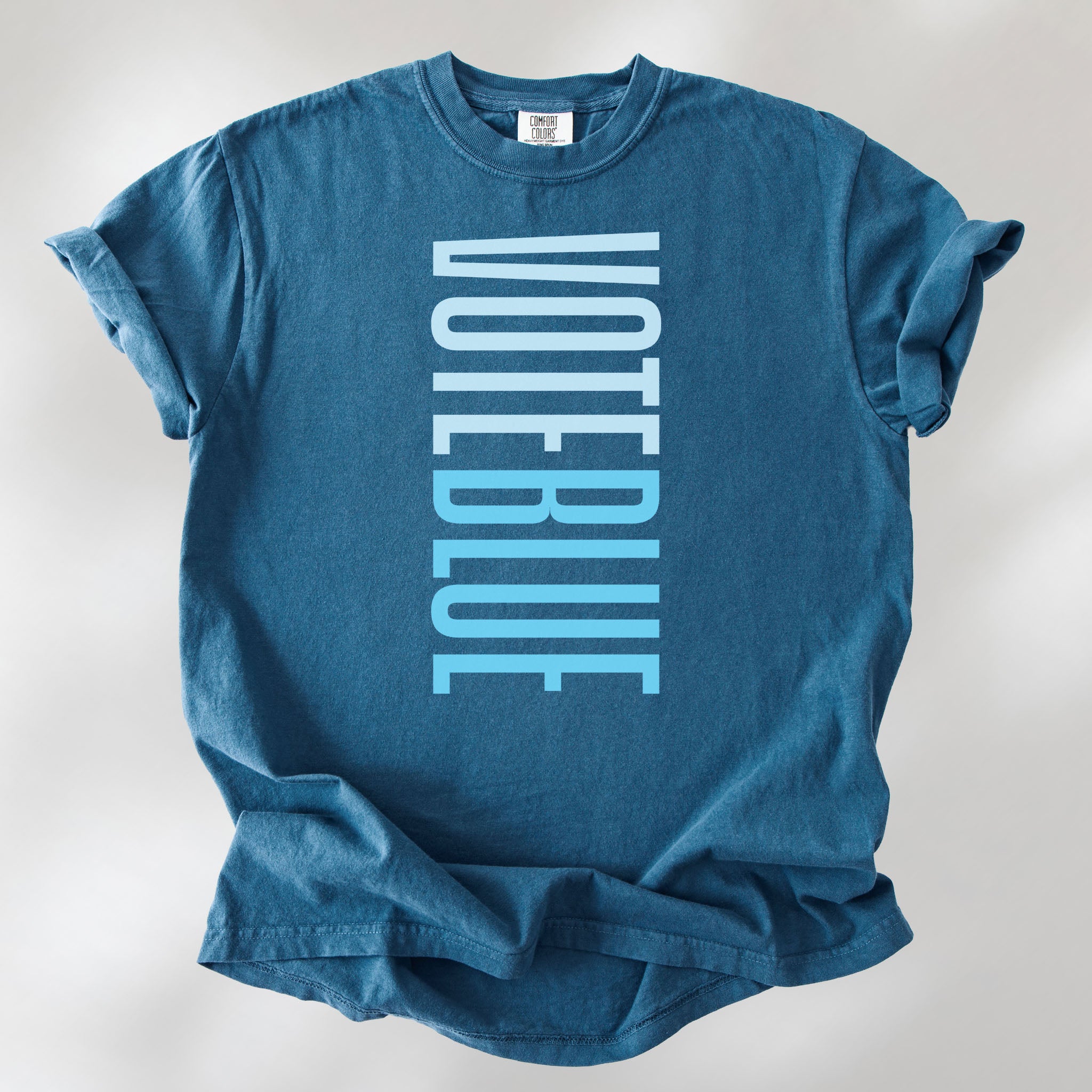 Midnight t-shirt featuring the words "VOTE BLUE" stacked vertically in bold minimalist blue typography.