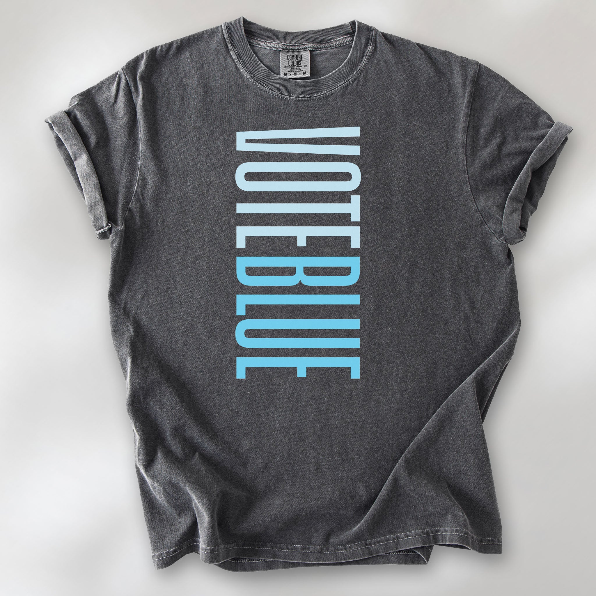 Pepper t-shirt featuring the words "VOTE BLUE" stacked vertically in bold minimalist blue typography.