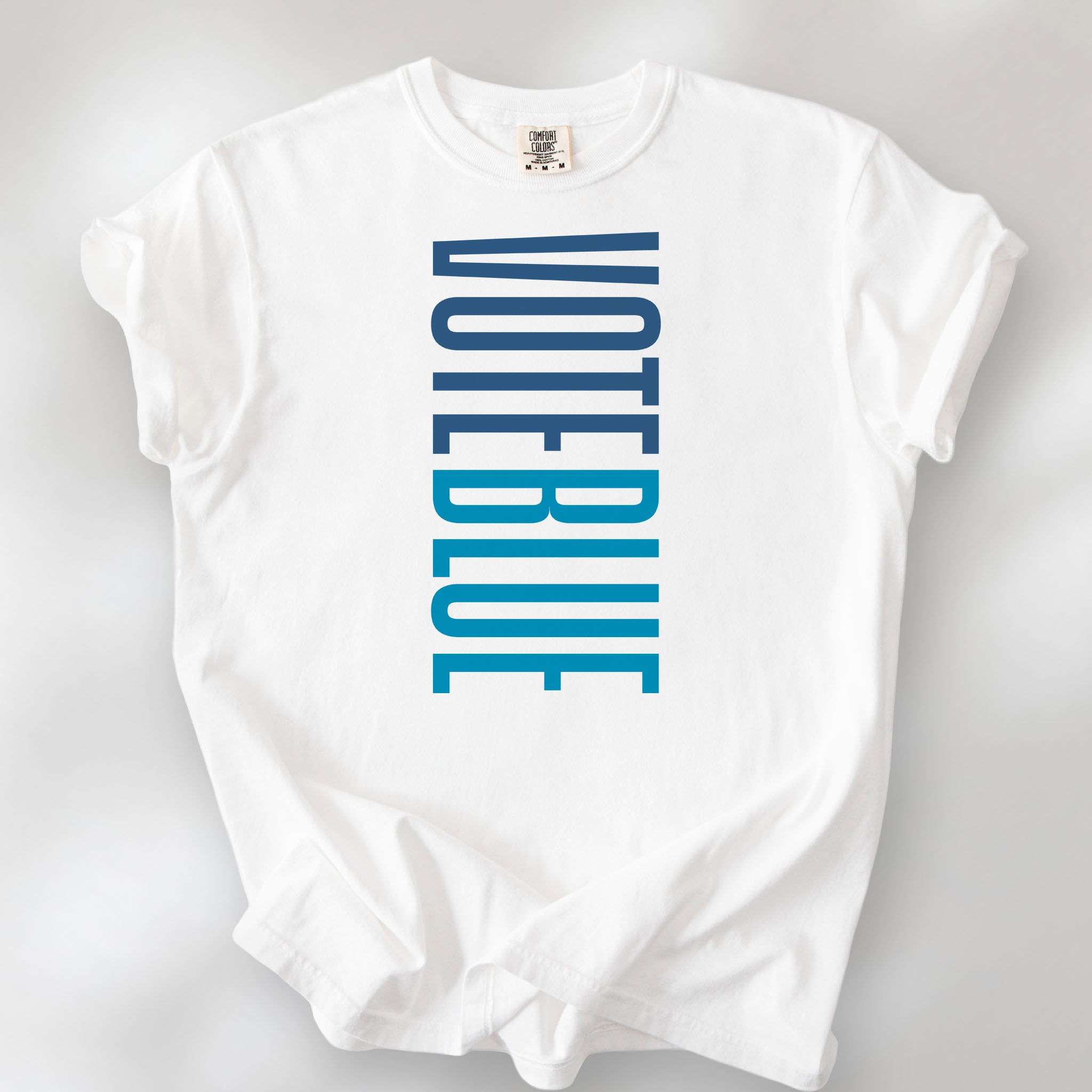 White t-shirt featuring the words "VOTE BLUE" stacked vertically in bold minimalist blue typography.
