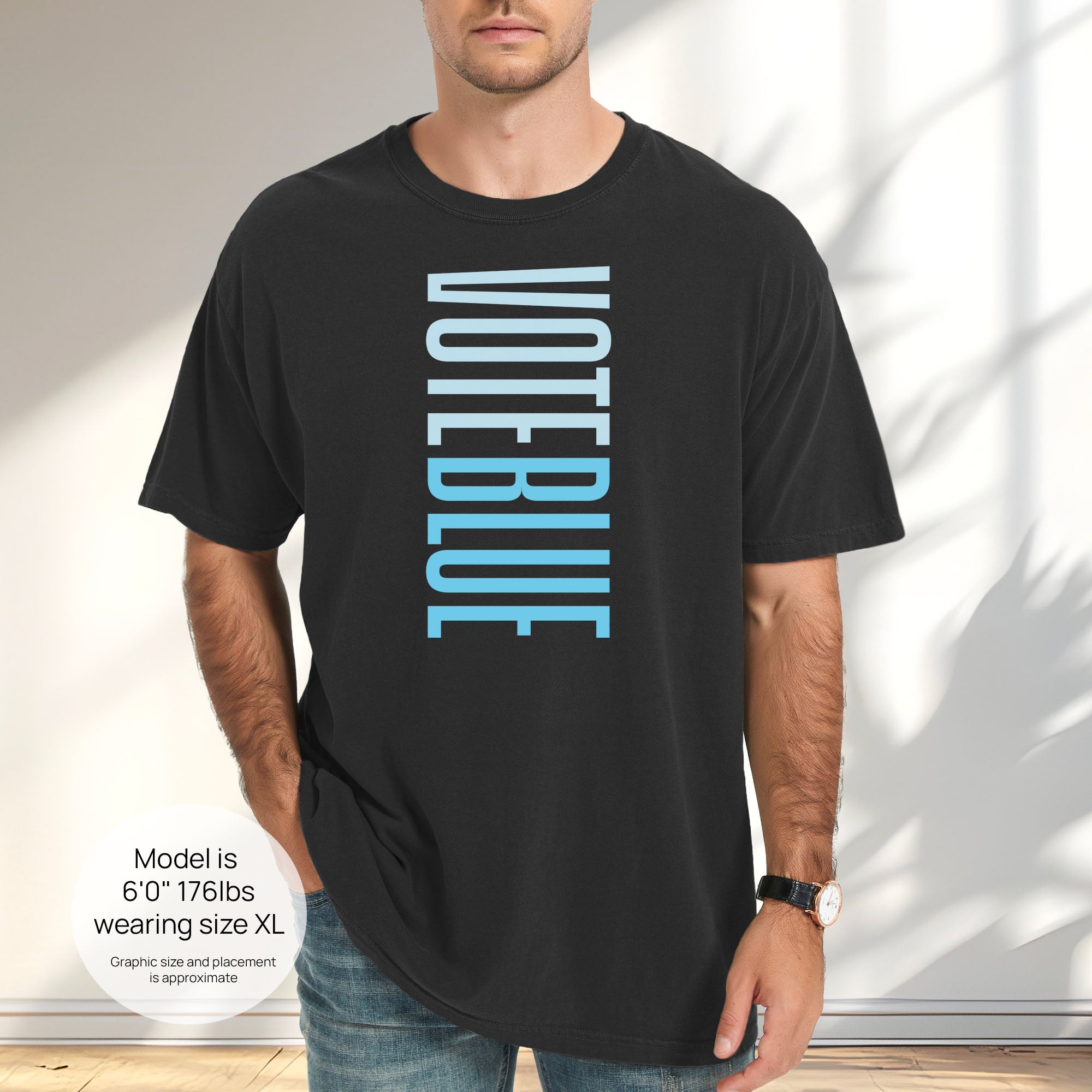 Male model wearing black t-shirt featuring the words "VOTE BLUE" stacked vertically in bold minimalist blue typography. Includes size and fit information for the model who is 6 feet 0 inches, 176 pounds, and wearing a size XL shirt.
