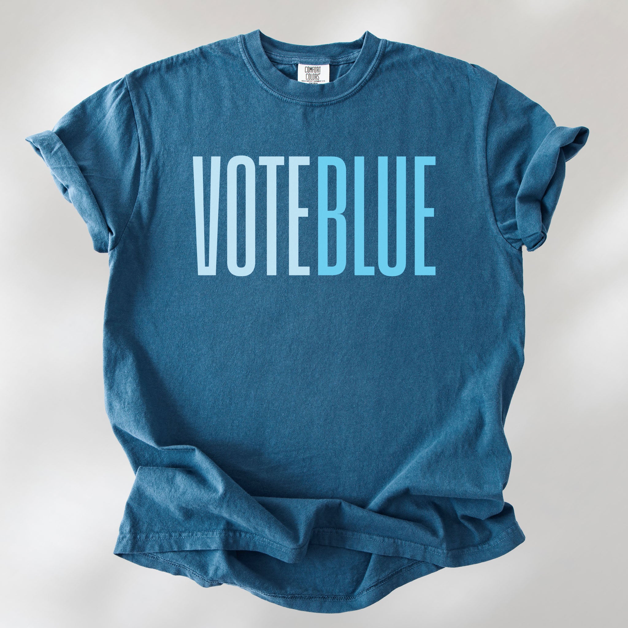 Midnight t-shirt featuring the words "VOTE BLUE" in bold horizontal blue geometric typography with a clean minimalist design.