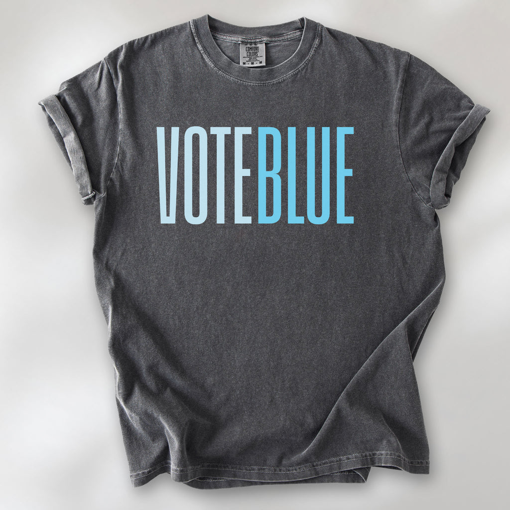Pepper t-shirt featuring the words "VOTE BLUE" in bold horizontal blue geometric typography with a clean minimalist design.
